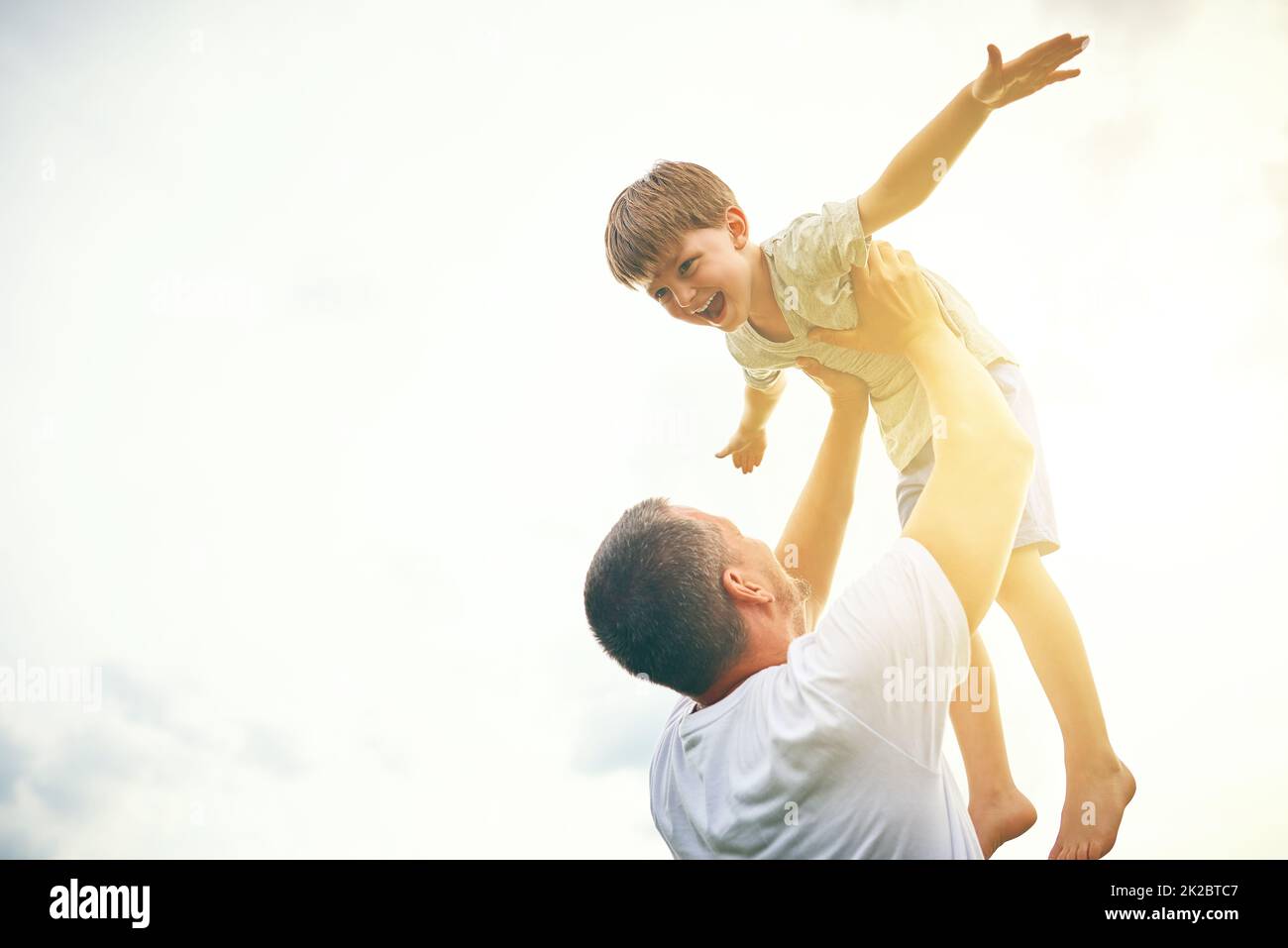 You getting bigger everyday but youre still my little boy. Cropped shot of a father tossing his adorable son into the air outside. Stock Photo
