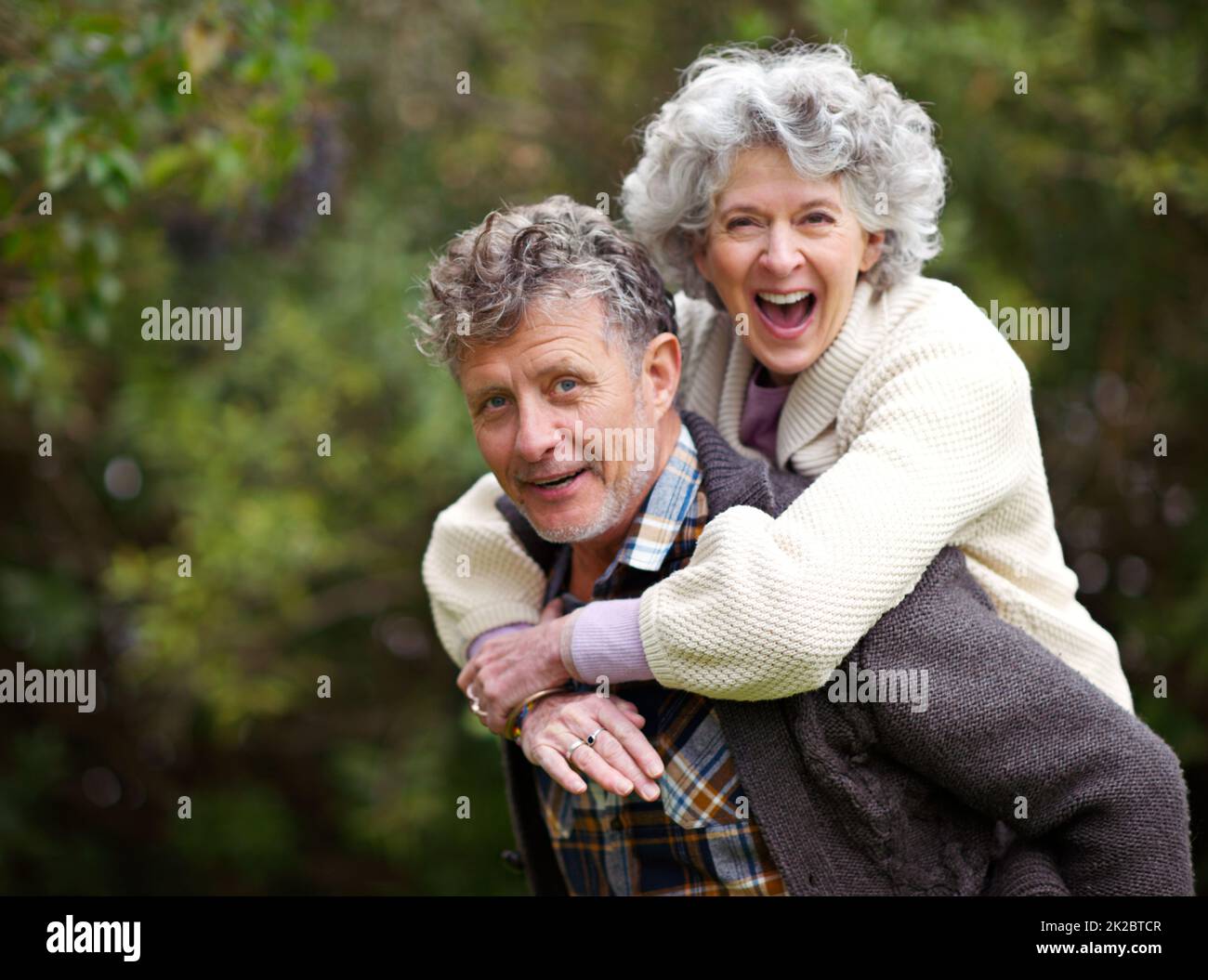 Golden moments together. Shot of a loving senior couple being playful outside. Stock Photo