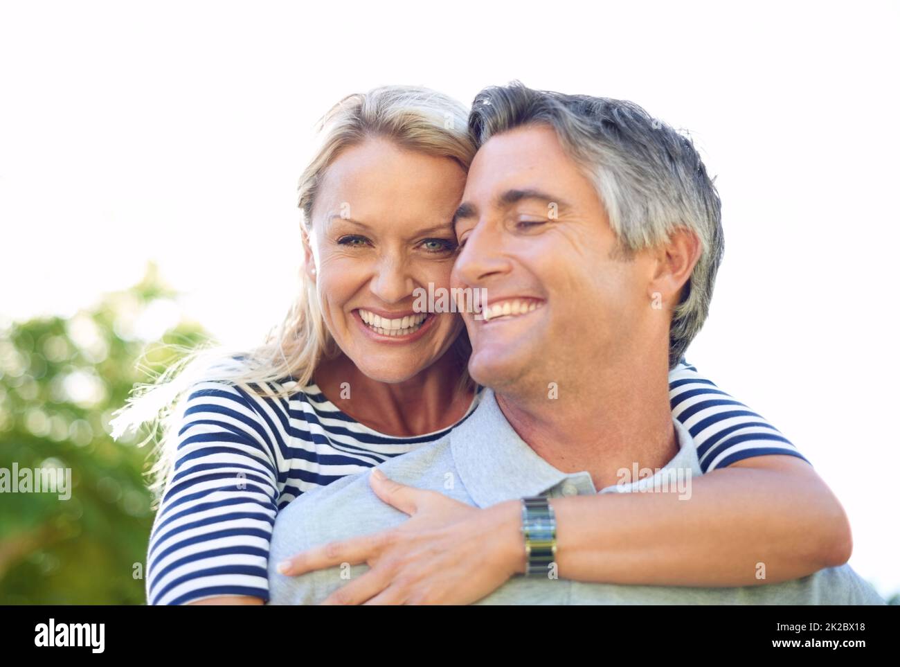 Moments to last a lifetime. Cropped portrait of an attractive mature woman on her husbands back in the park. Stock Photo