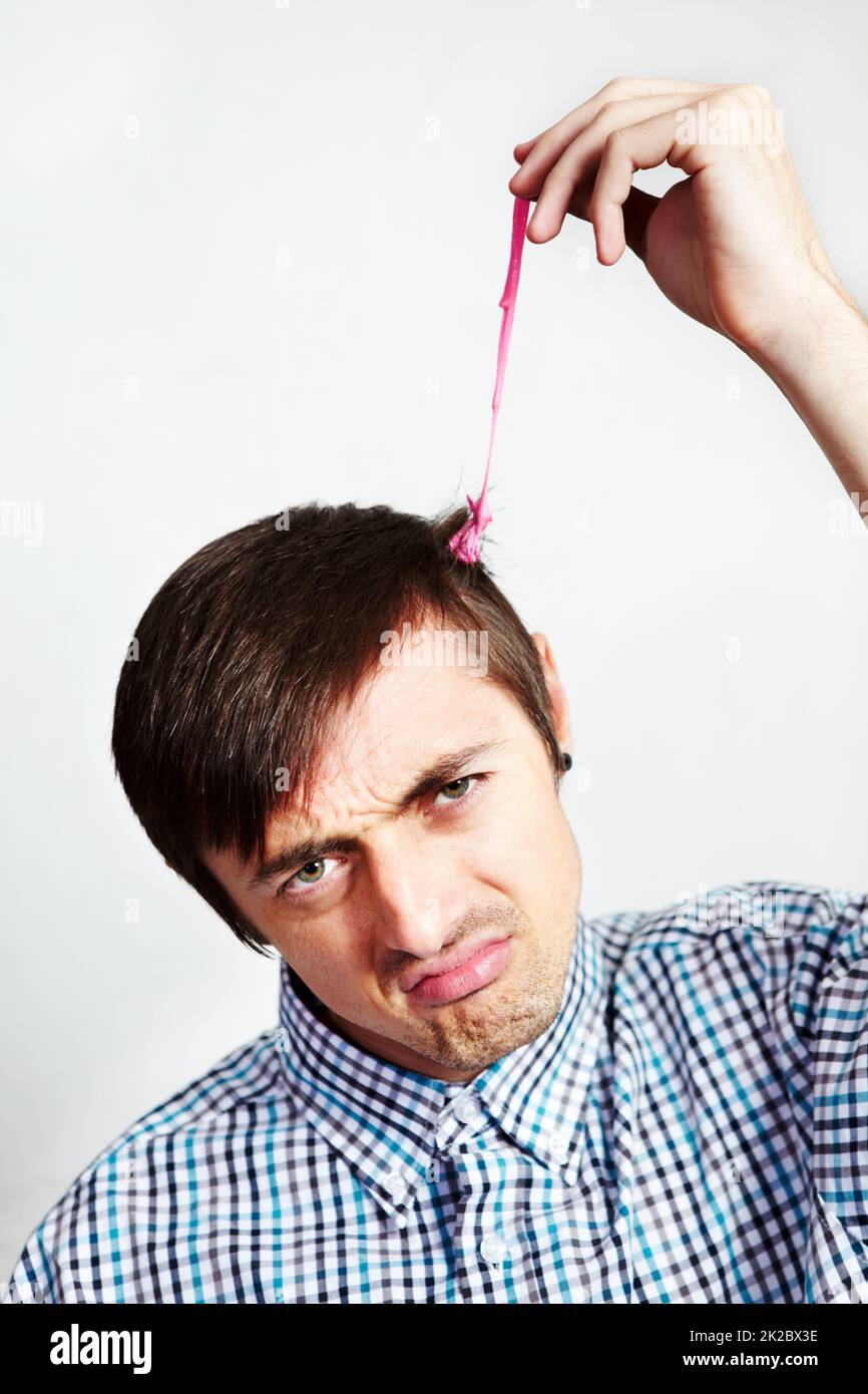 Thats a sticky situation. Portrait of a digruntled man with bubblegum in his hair. Stock Photo