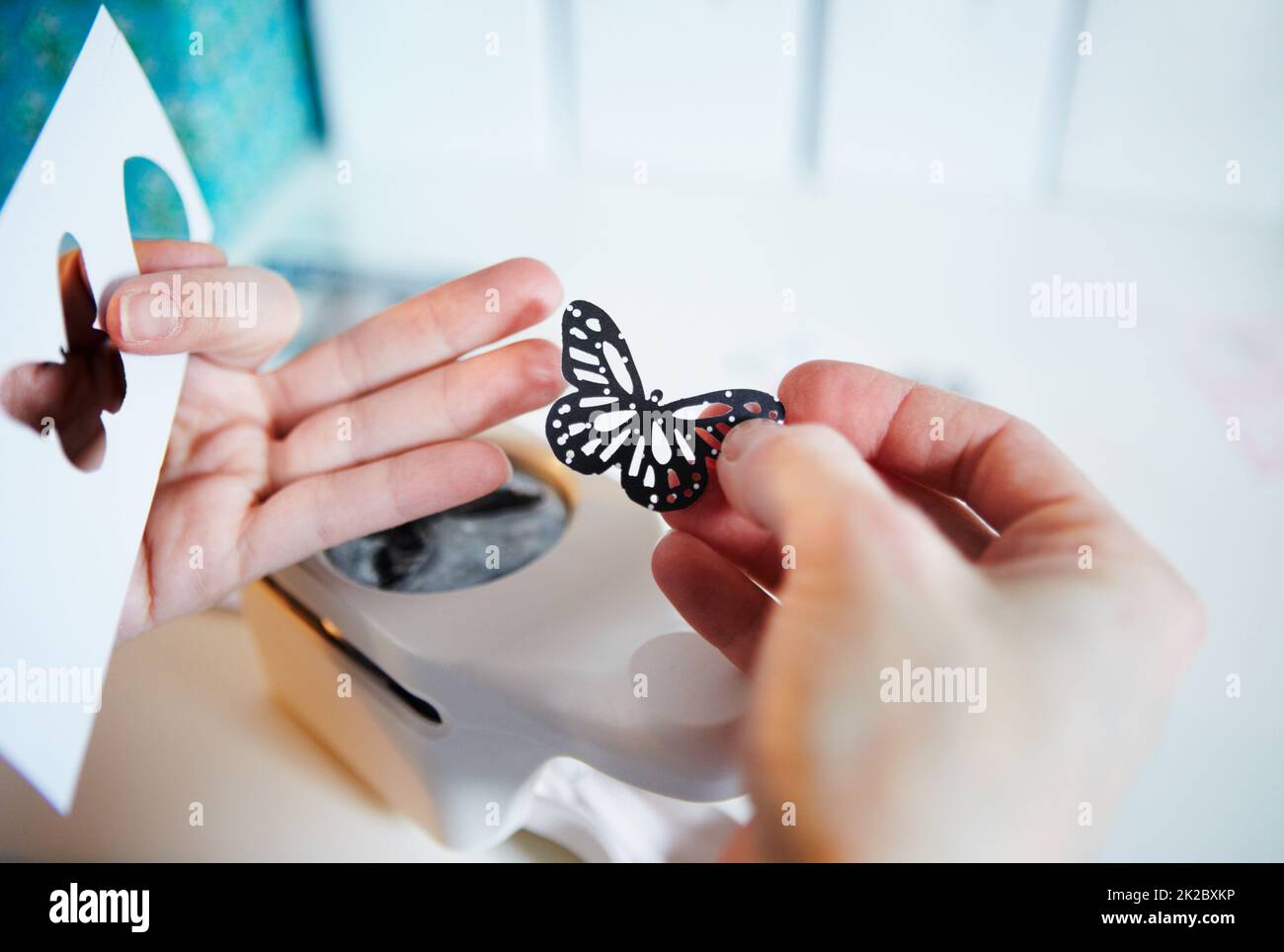 The right tools for crafting. Cropped shot of a womans hands holding a punched out paper butterfly. Stock Photo