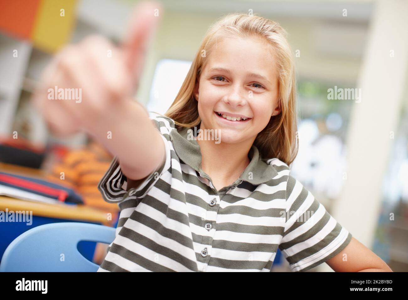 My school is awesome. Sweet elementary school girl giving you a thumbs