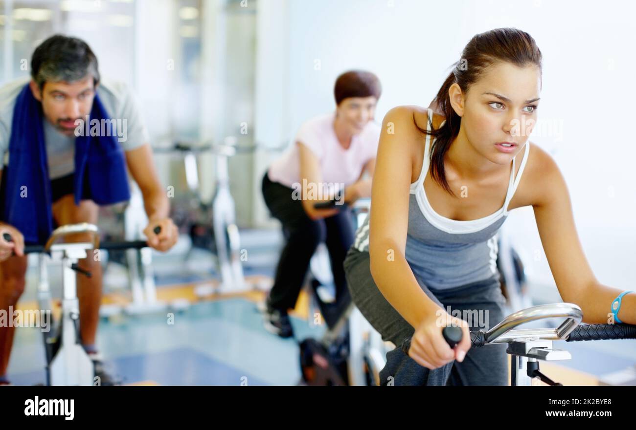 Woman practicing on speed bike at gym. Beautiful woman working out on a stationary bike at the gym. Stock Photo