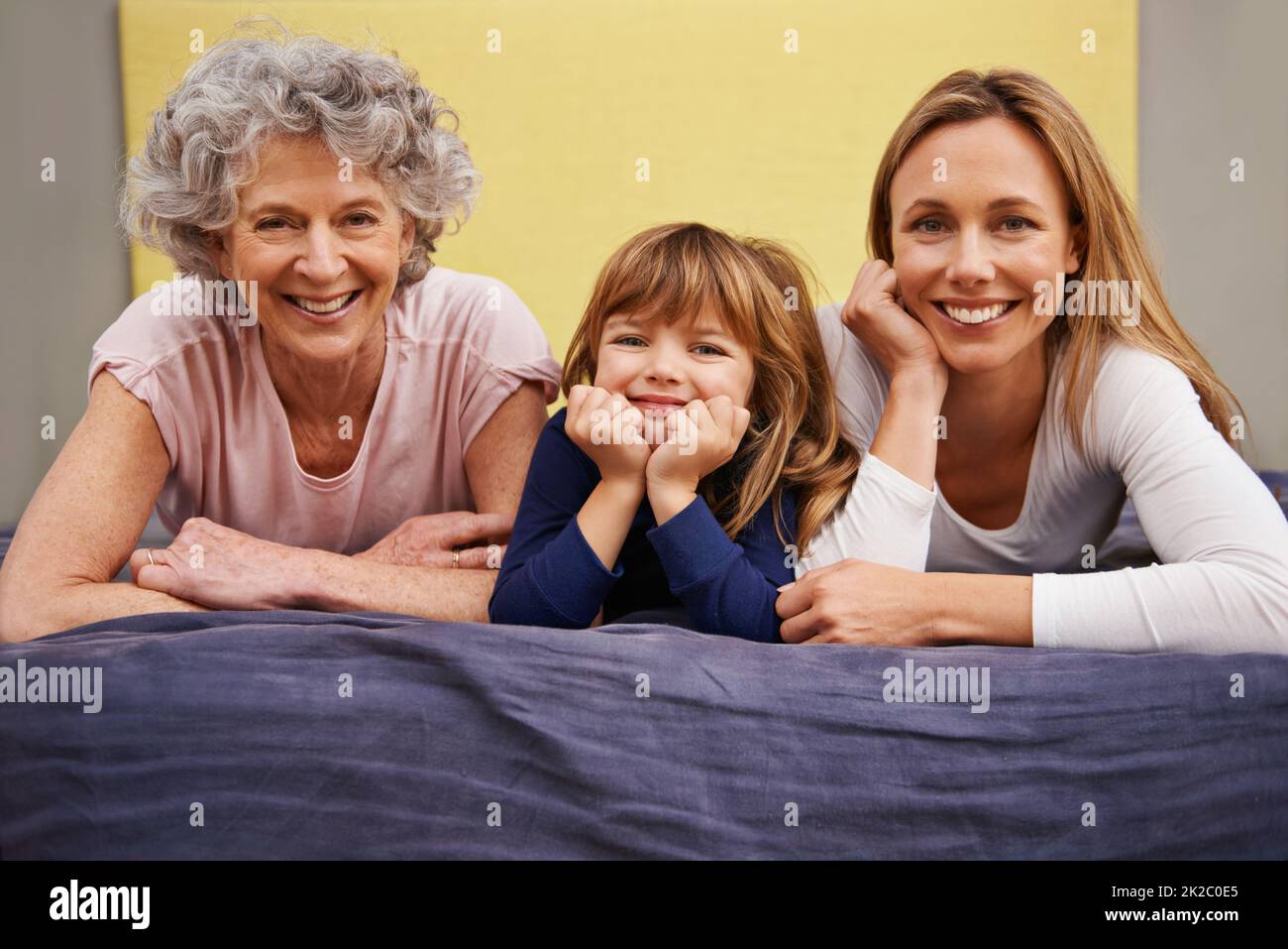 Making time to bond as a family. Portrait of a little girl and her mother and grandmother lying on a bed. Stock Photo