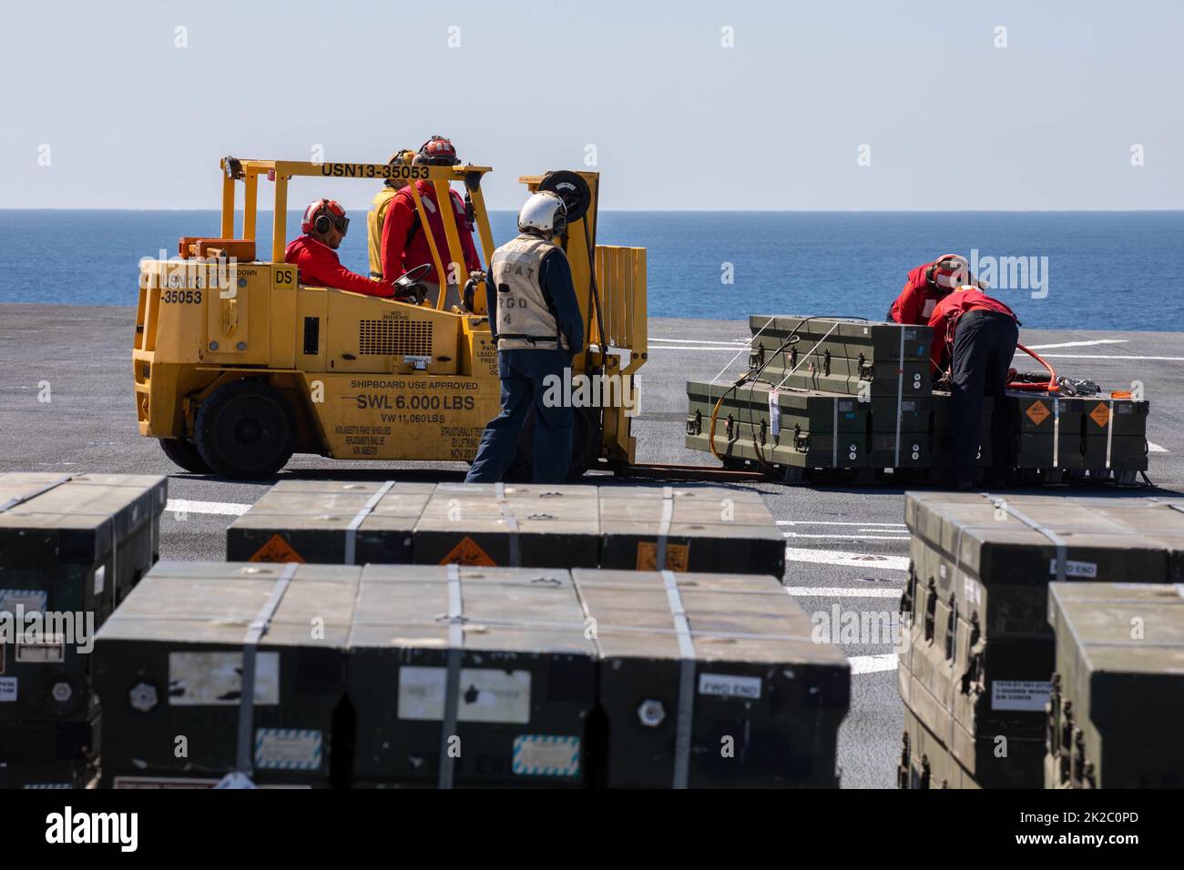 220915-N-VS068-1044    PACIFIC OCEAN (Sept. 15, 2022) – Sailors use a forklift to transport a palette during an ammunition onload evolution on the flight deck ammunition magazine aboard amphibious assault ship USS Makin Island (LHD 8), Sept. 15. Aviation Ordnancemen operate and handle aviation ordnance equipment and are responsible for the stowage and loading of munitions and small arms. The Makin Island Amphibious Ready Group, comprised of amphibious assault ship USS Makin Island (LHD 8) and amphibious transport docks USS Anchorage (LPD 23) and USS John P. Murtha (LPD 26), is underway conduct Stock Photo