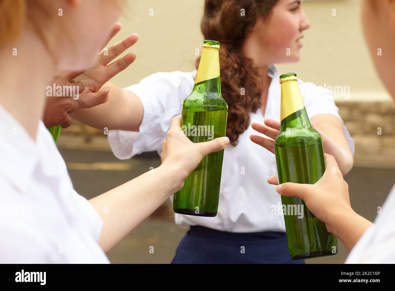 No. Young female student turning down alcohol in response to peer pressure. Stock Photo