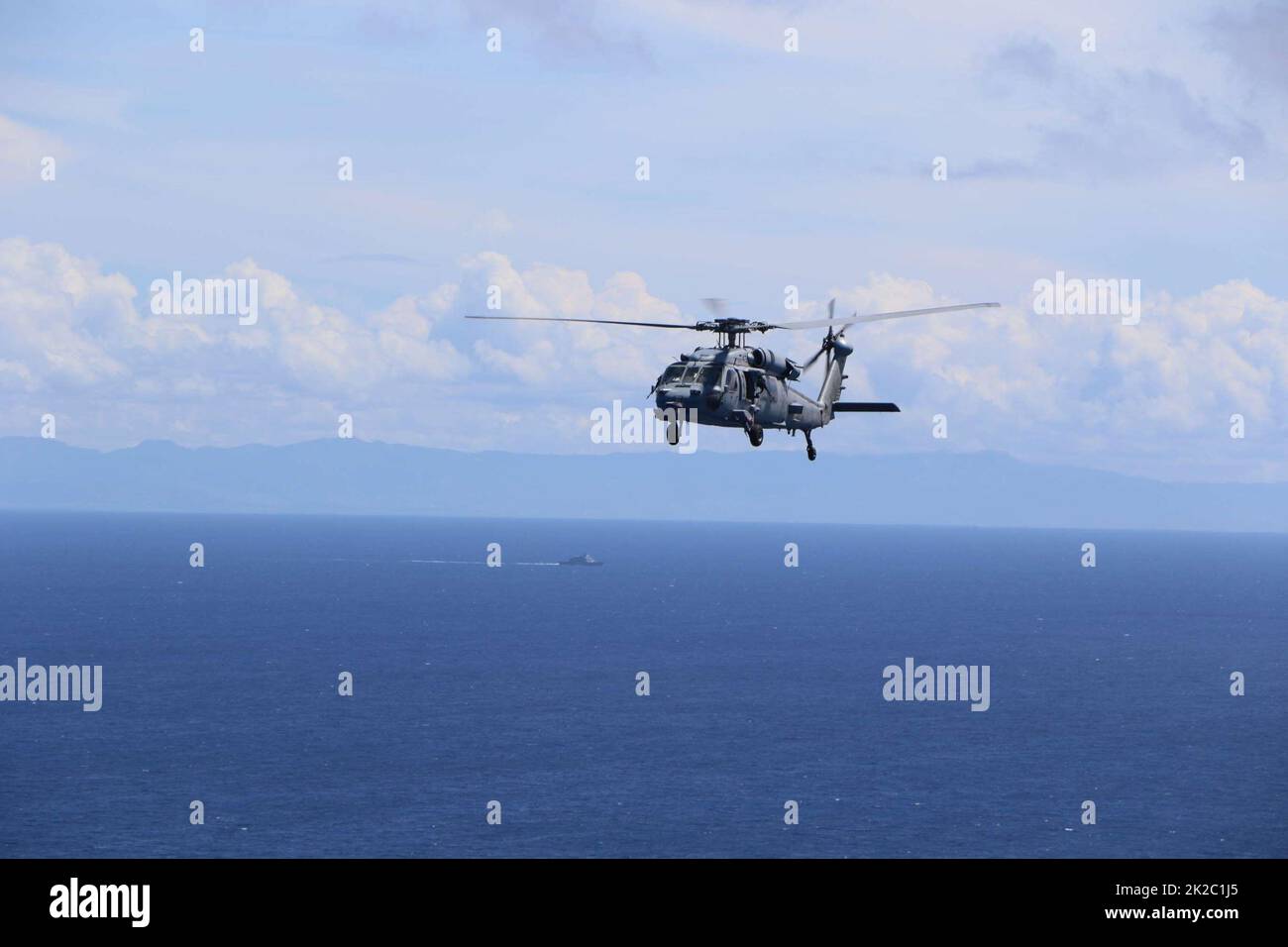 220910-N-N3764-3001  CARIBBEAN SEA - (Sept. 10, 2022) -- An MH-60S Sea Hawk helicopter assigned to Helicopter Sea Combat Squadron (HSC) 28, Detachment 8, participates in a photo exercise overlooking the Freedom-variant littoral combat ship USS Billings (LCS 15) in the Caribbean Sea, Sept. 10, 2022. Billings is deployed to the U.S. 4th Fleet area of operations to support Joint Interagency Task Force South’s mission, which includes counter-illicit drug trafficking missions in the Caribbean and Eastern Pacific. (U.S. Navy courtesy photo/Released) Stock Photo