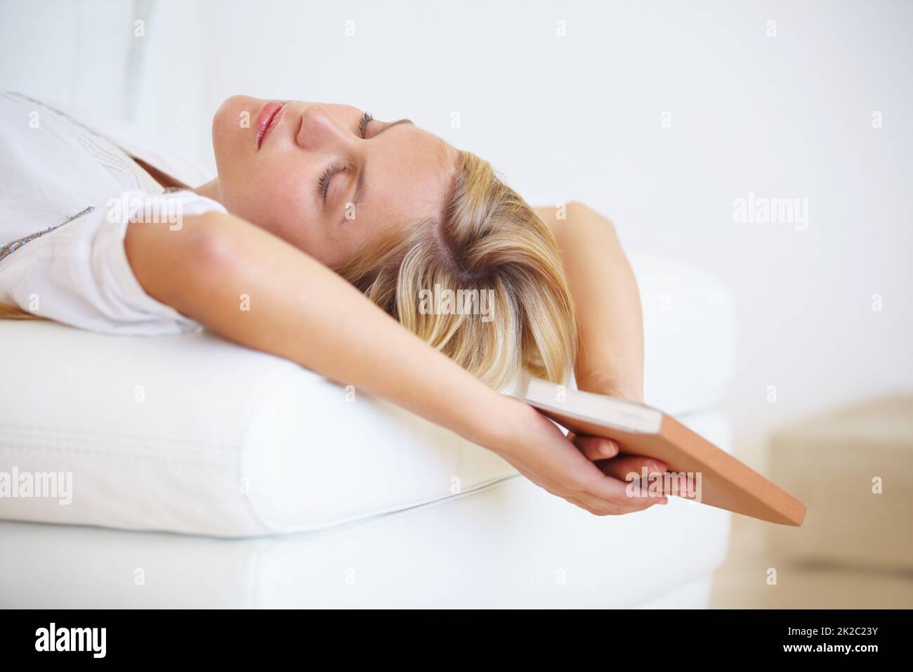 Reading makes her sleepy. An attractive young woman falling asleep on