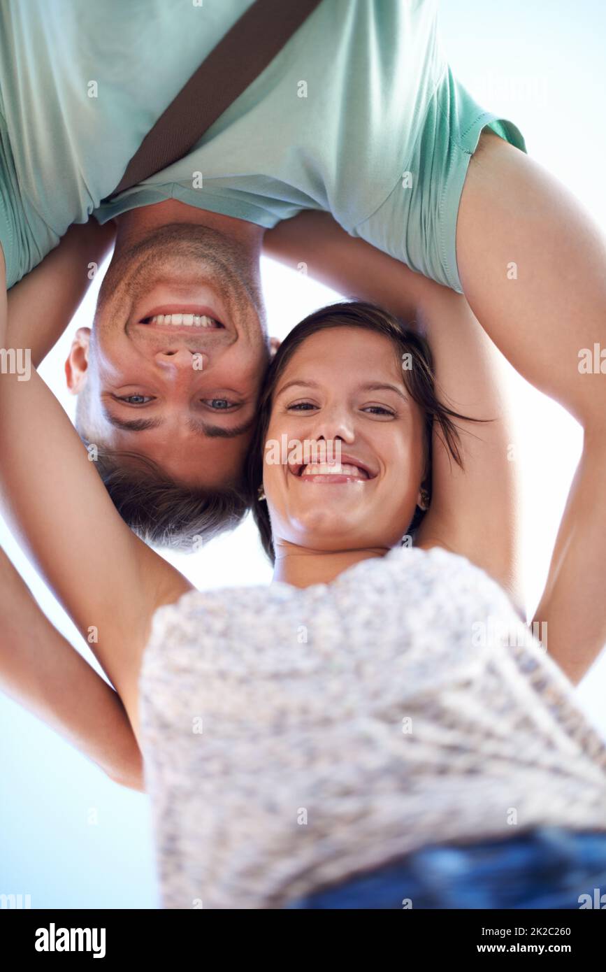 Hi there. Cropped view of a young couple smiling while looking down at the camera. Stock Photo