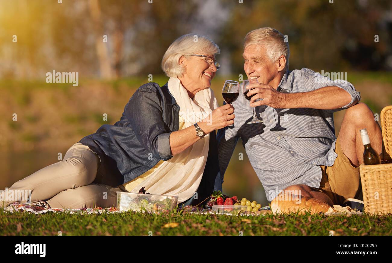 True love is timeless. Shot of a happy senior couple enjoying a picnic outdoors. Stock Photo