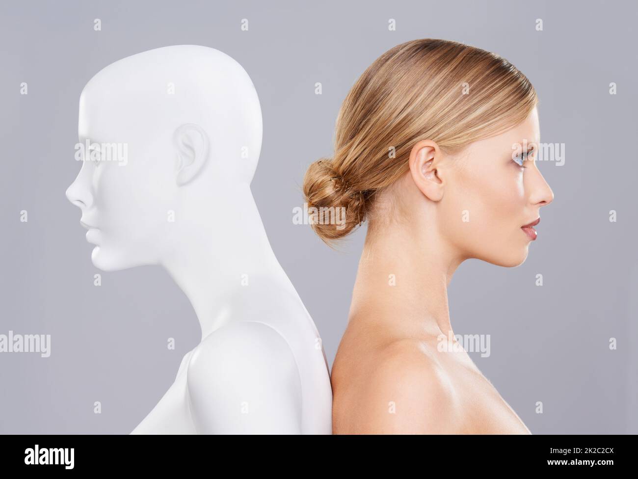 Real vs artificial beauty. A beautiful young woman standing back to