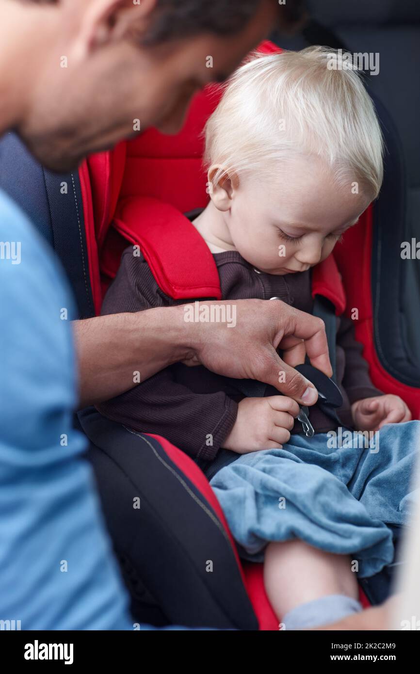 Ein Baby in der Sonnenbrille seiner Mutter sitzt in einem Auto in einem  Kindersitz und zeigt seine Zunge aus dem Fenster Stockfotografie - Alamy