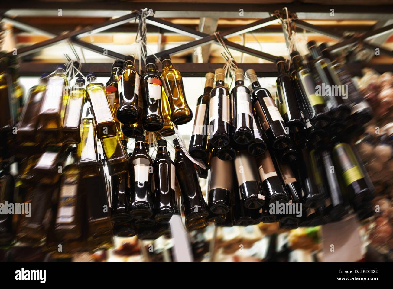 Only the best olive oil. Hanging bottles of olive oil at a food market