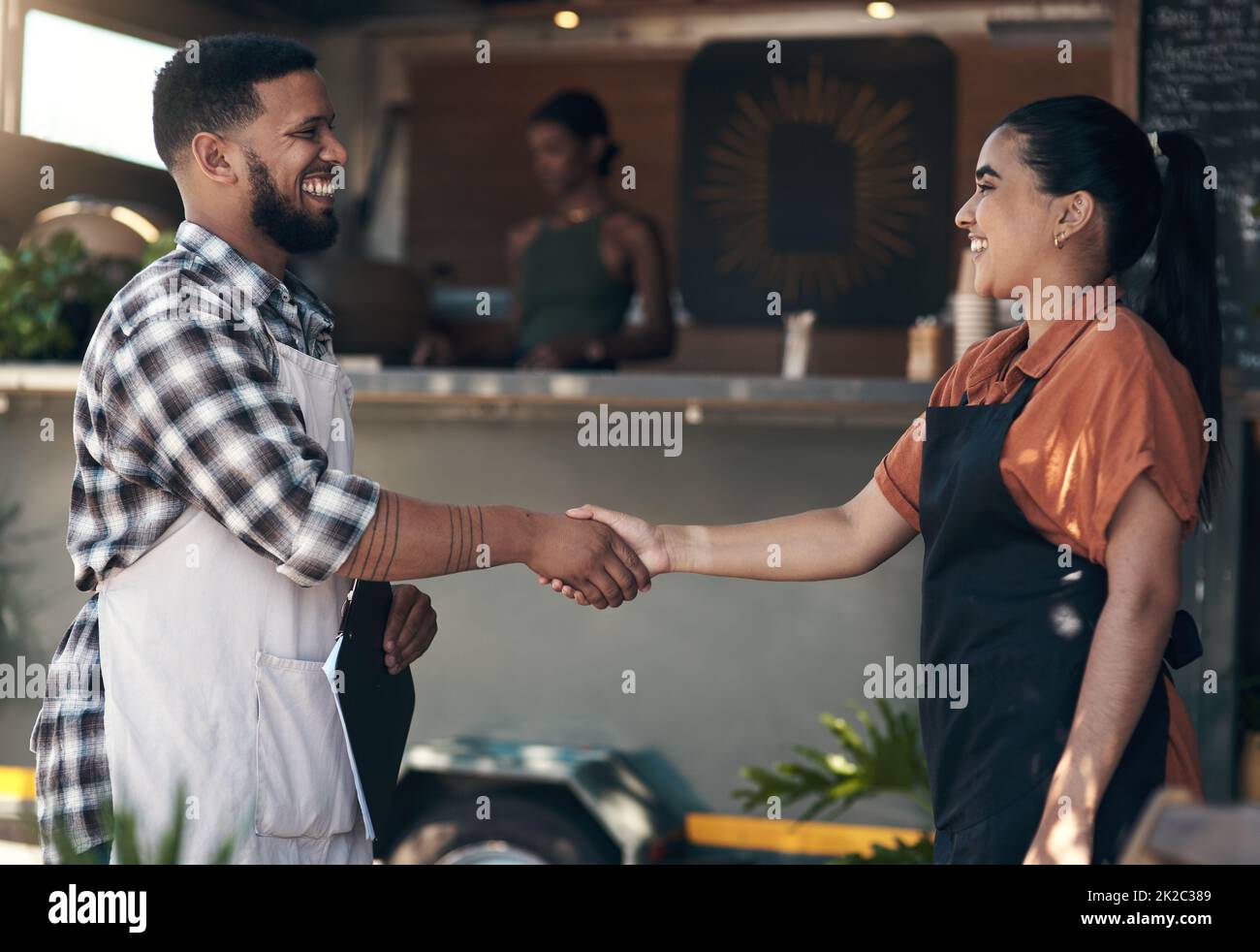Welcome to the team. Shot of two young restaurant owners standing outside together and shaking hands. Stock Photo