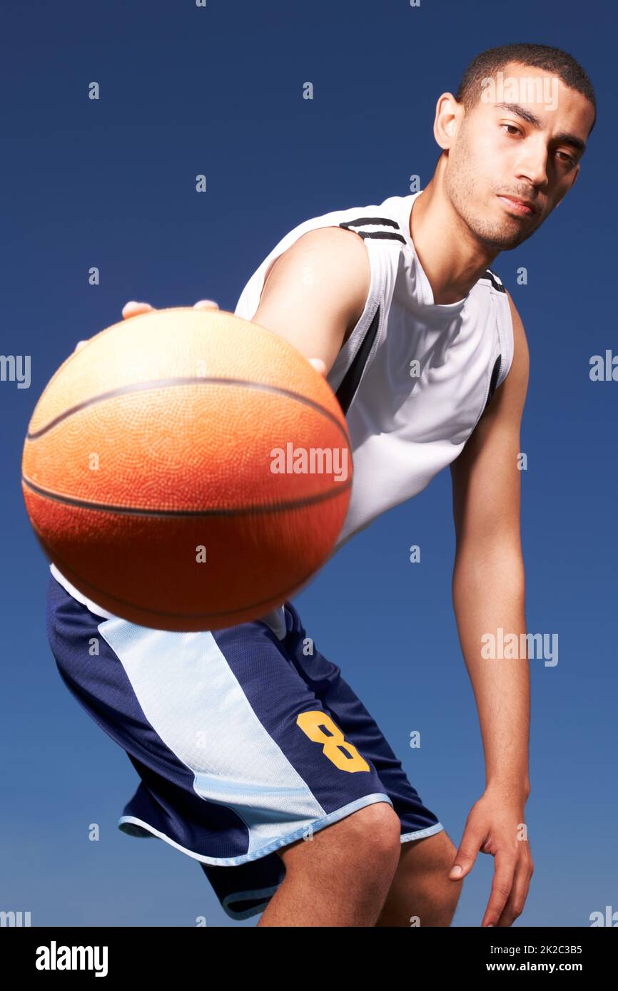 Play ball. A young mixed-race sportsplayer dribbles a ball. Stock Photo