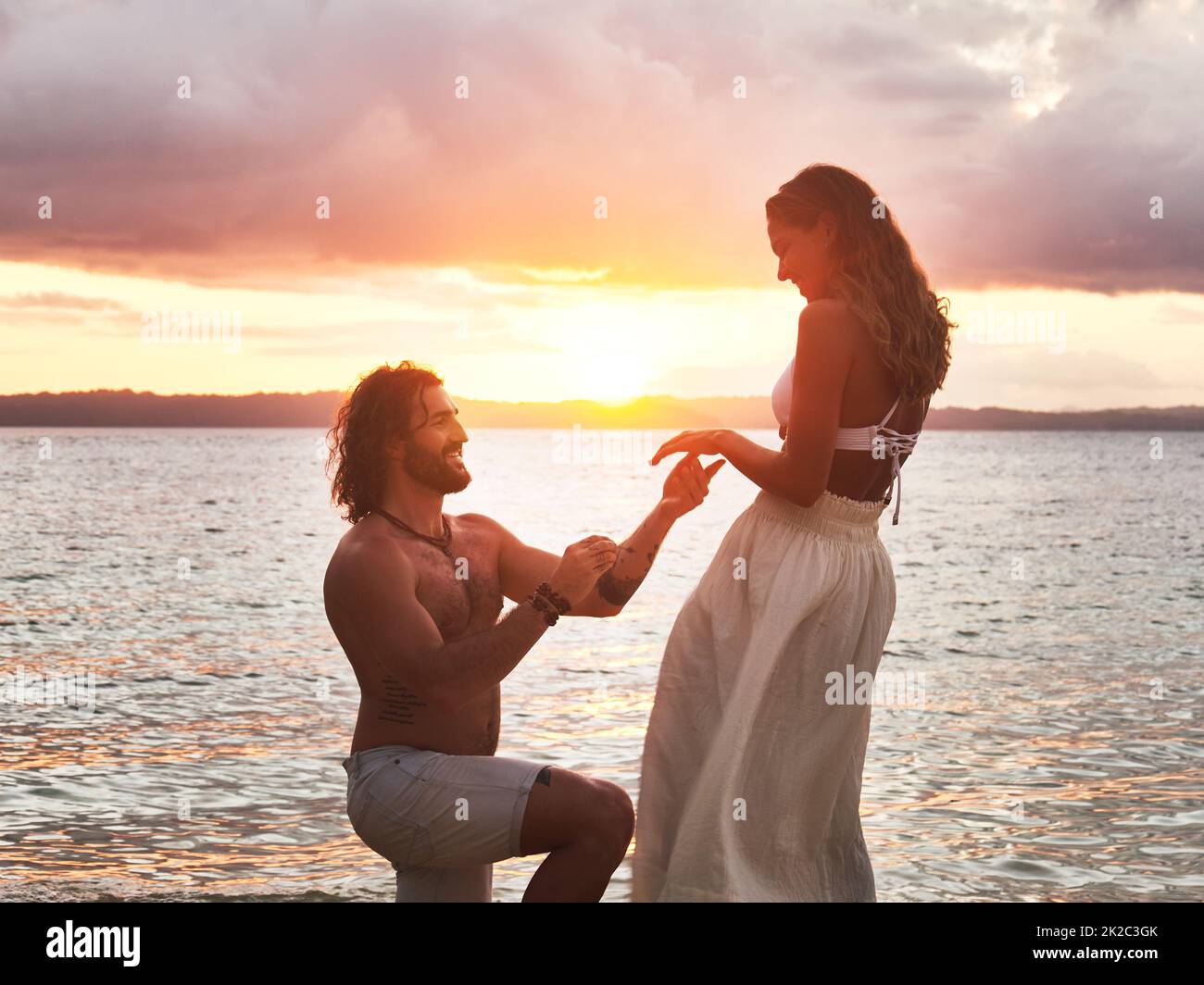 He popped the question at the most scenic place. Shot of a young man proposing to his girlfriend at the beach. Stock Photo