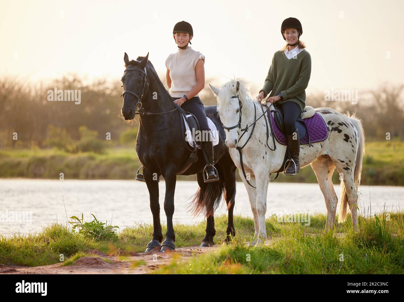 Horses are powerful yet majestic. Shot of two young women riding their horses outside on a field. Stock Photo