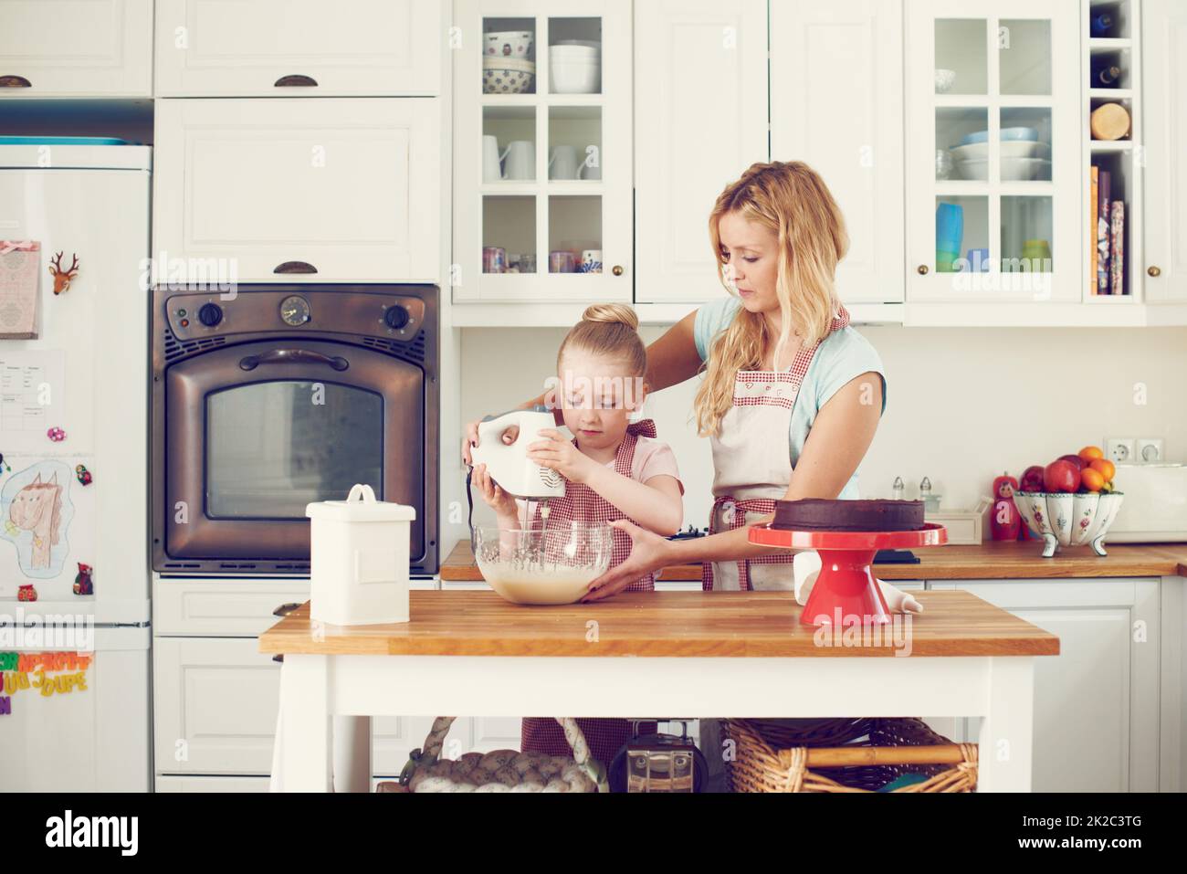 Mixing up the ingredients together. Cute little girl baking in the