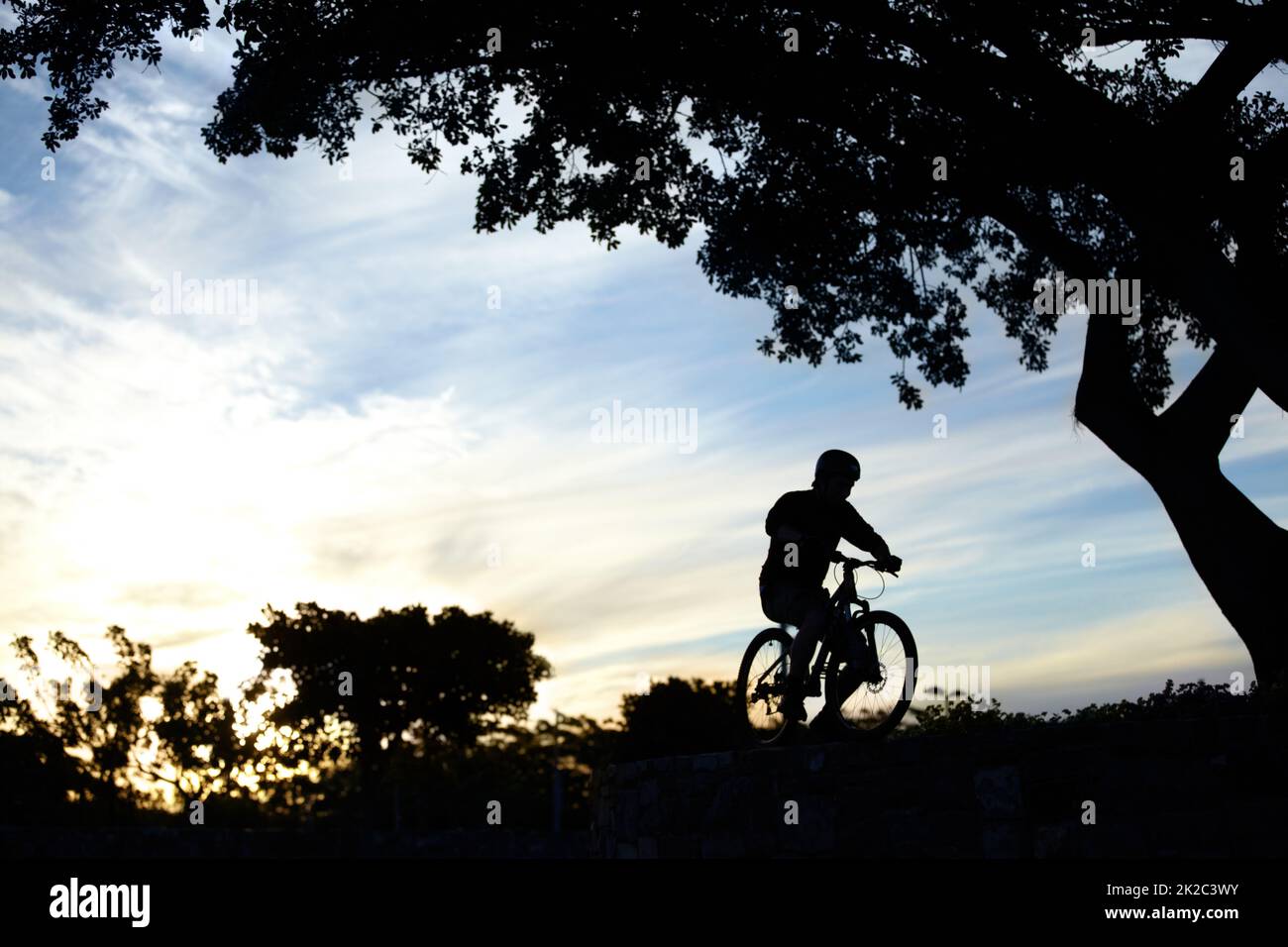 Ride on.... Silhouette shot of a man riding his bike at dusk. Stock Photo