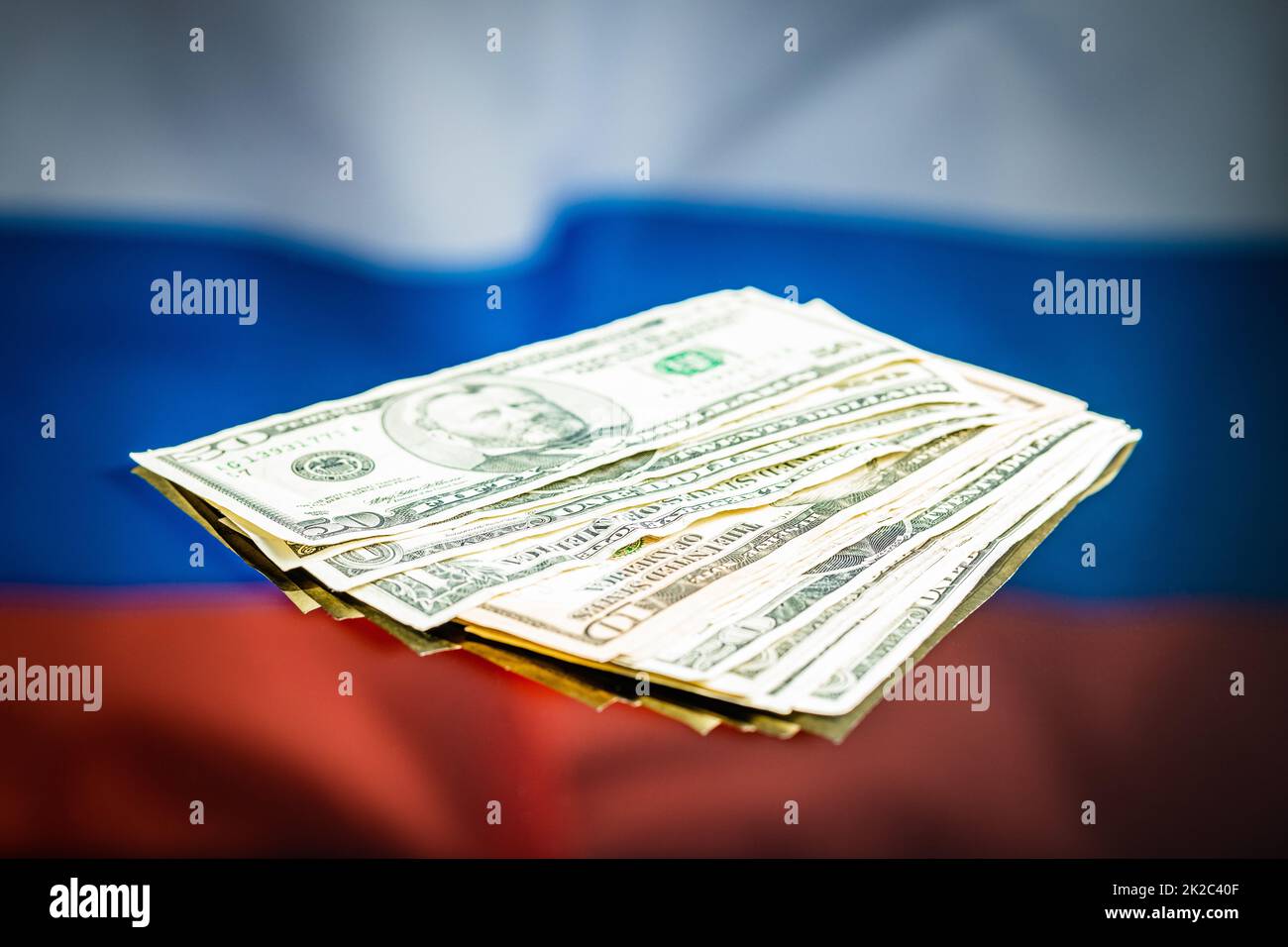 Dollar banknotes in front of Russian flag. Paper US currency. Stock Photo