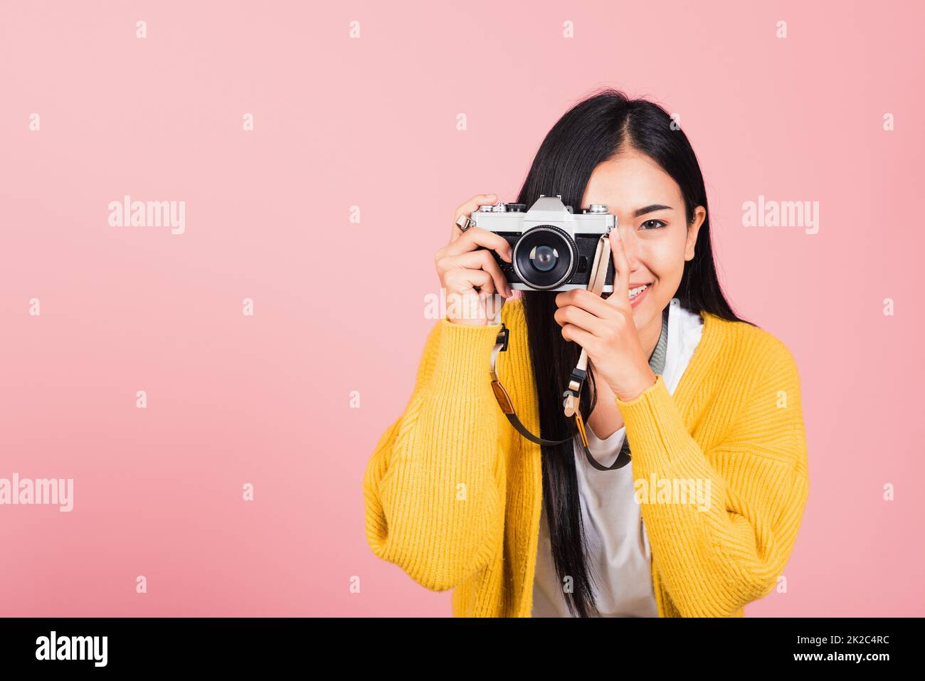 woman smiling photographer taking a picture and looking viewfinder on