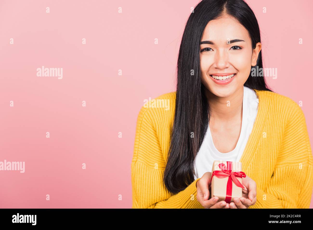 woman smiling holding small gift box on hands Stock Photo