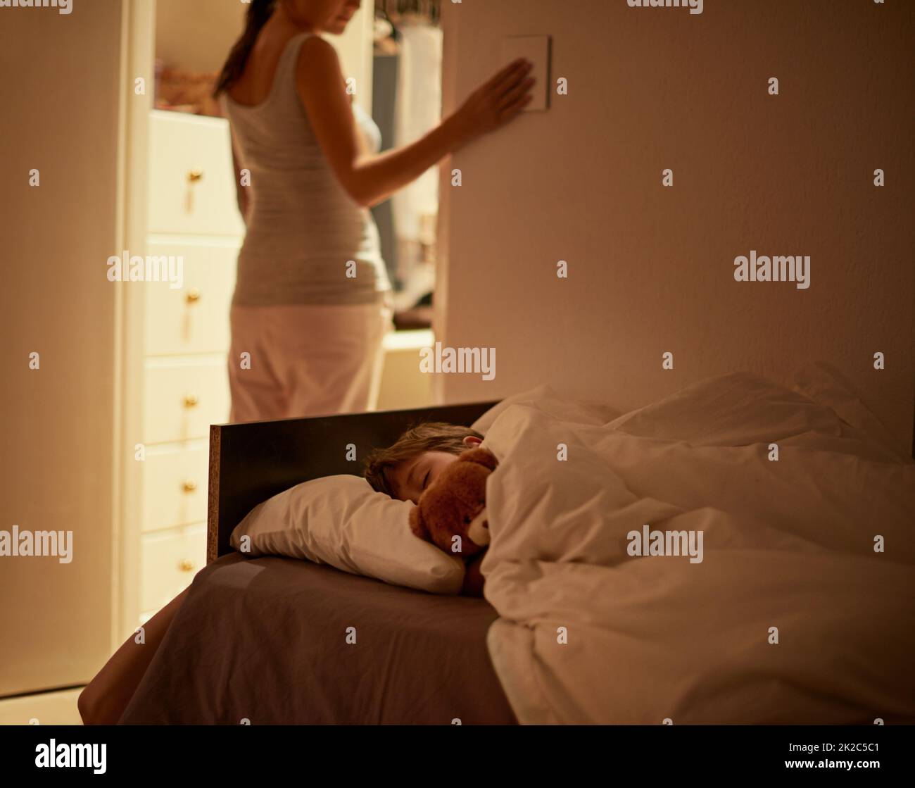 Sleep tight my boy. Shot of a mother turning off the light as her son sleeps peacefully in bed. Stock Photo