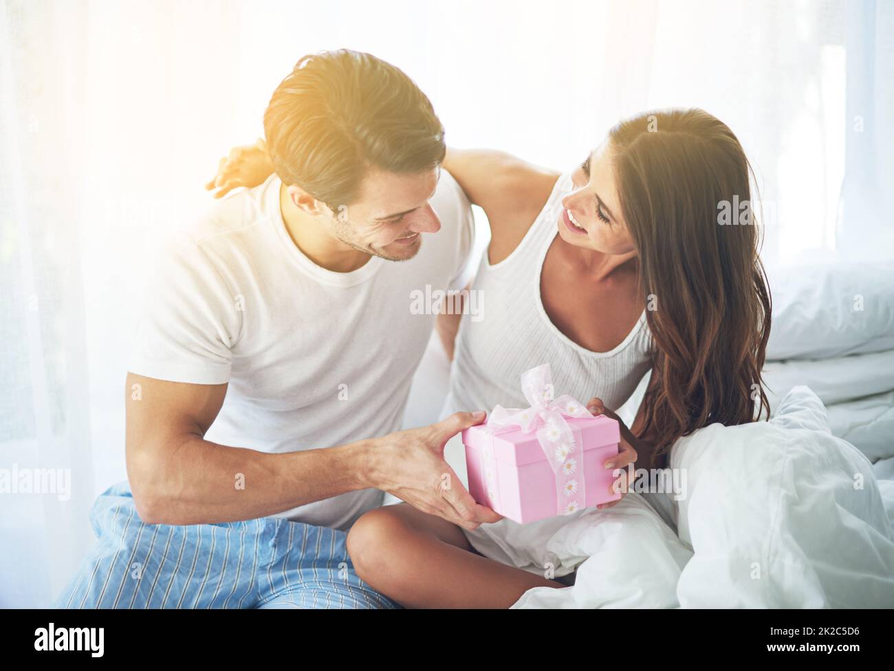 Ive got a little surprise for you. Shot of a loving husband giving his wife a gift. Stock Photo