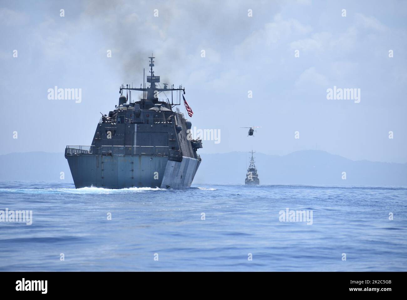 220919-N-N3764-1005  OCHO RIOS, Jamaica - (Sept. 19, 2022) – The Freedom-variant littoral combat ship USS Billings (LCS 15) and Her Majesty’s Jamaican Ship (HMJS) Alexander Bustamante along with a helicopter assigned to the Jamaican Defense Force (JDF) participate in a photo exercise offshore of Ocho Rios, Jamaica, Sept. 19, 2022. Billings is deployed to the U.S. 4th Fleet area of operations to support Joint Interagency Task Force South’s mission, which includes counter-illicit drug trafficking missions in the Caribbean and Eastern Pacific. (U.S. Navy photo by Mineman 2nd Class Justin Hovarter Stock Photo