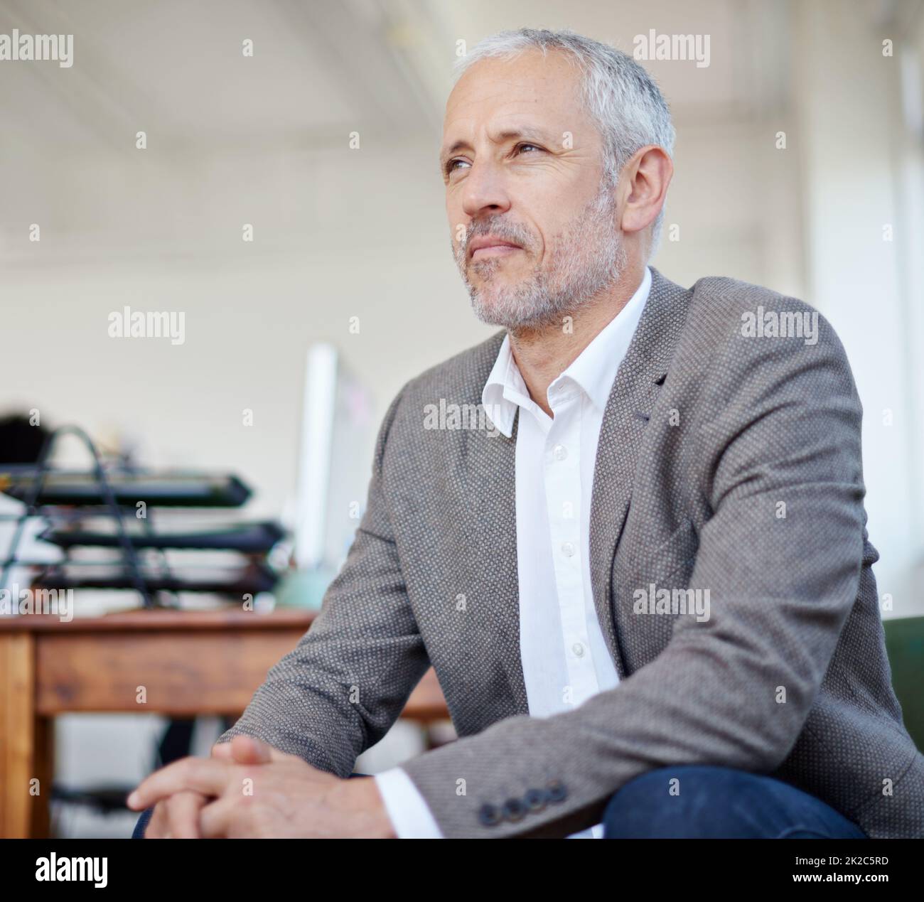 Thinking about his business future. Shot of a mature businessman sitting in an office. Stock Photo