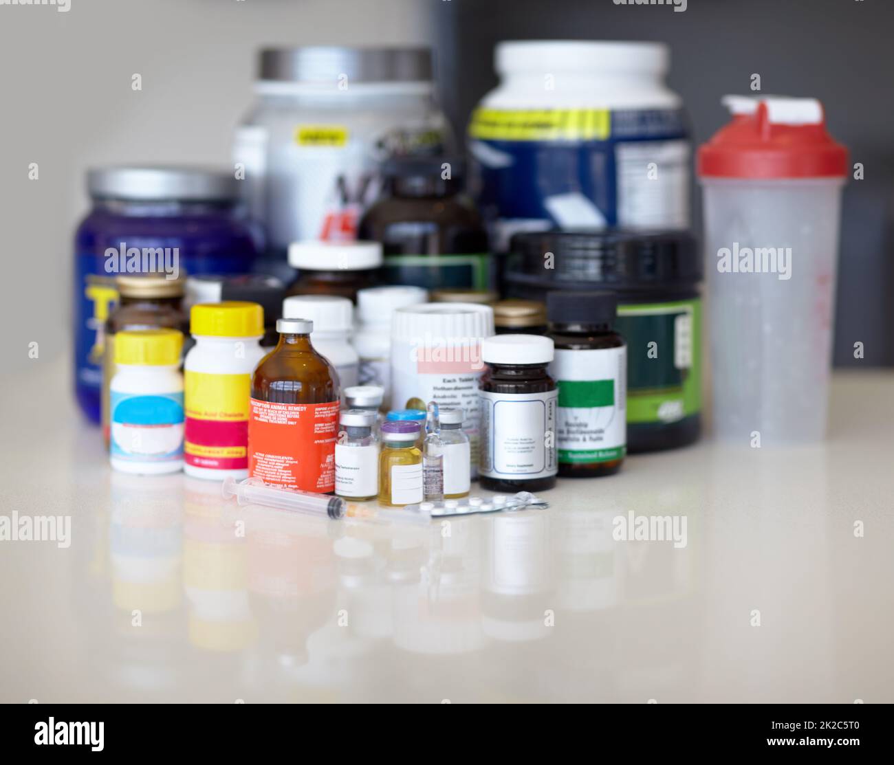 Feeding the addiction. Medicine bottles and pills with protein shakes and meal replacements. Stock Photo
