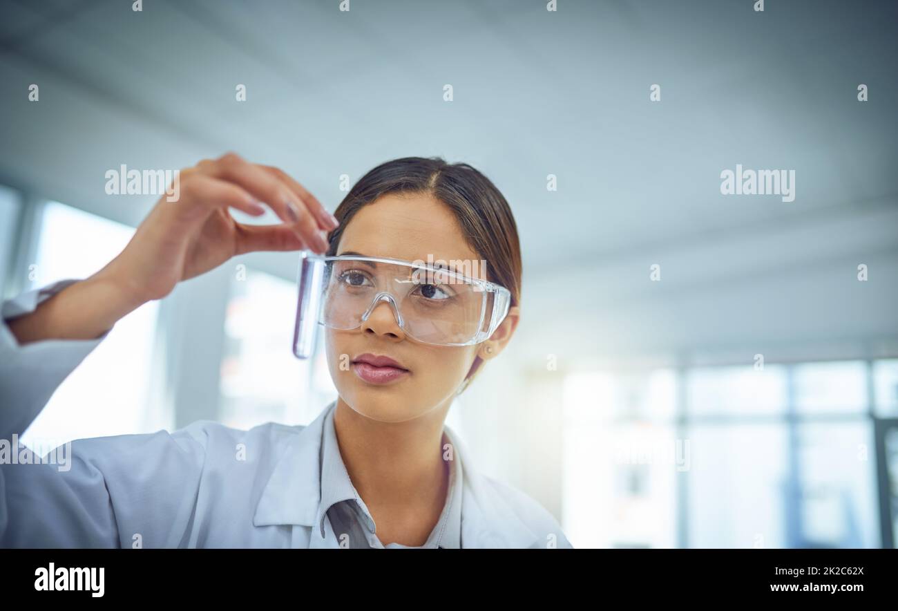 This could be the cure. Shot of a young scientist working in a lab. Stock Photo