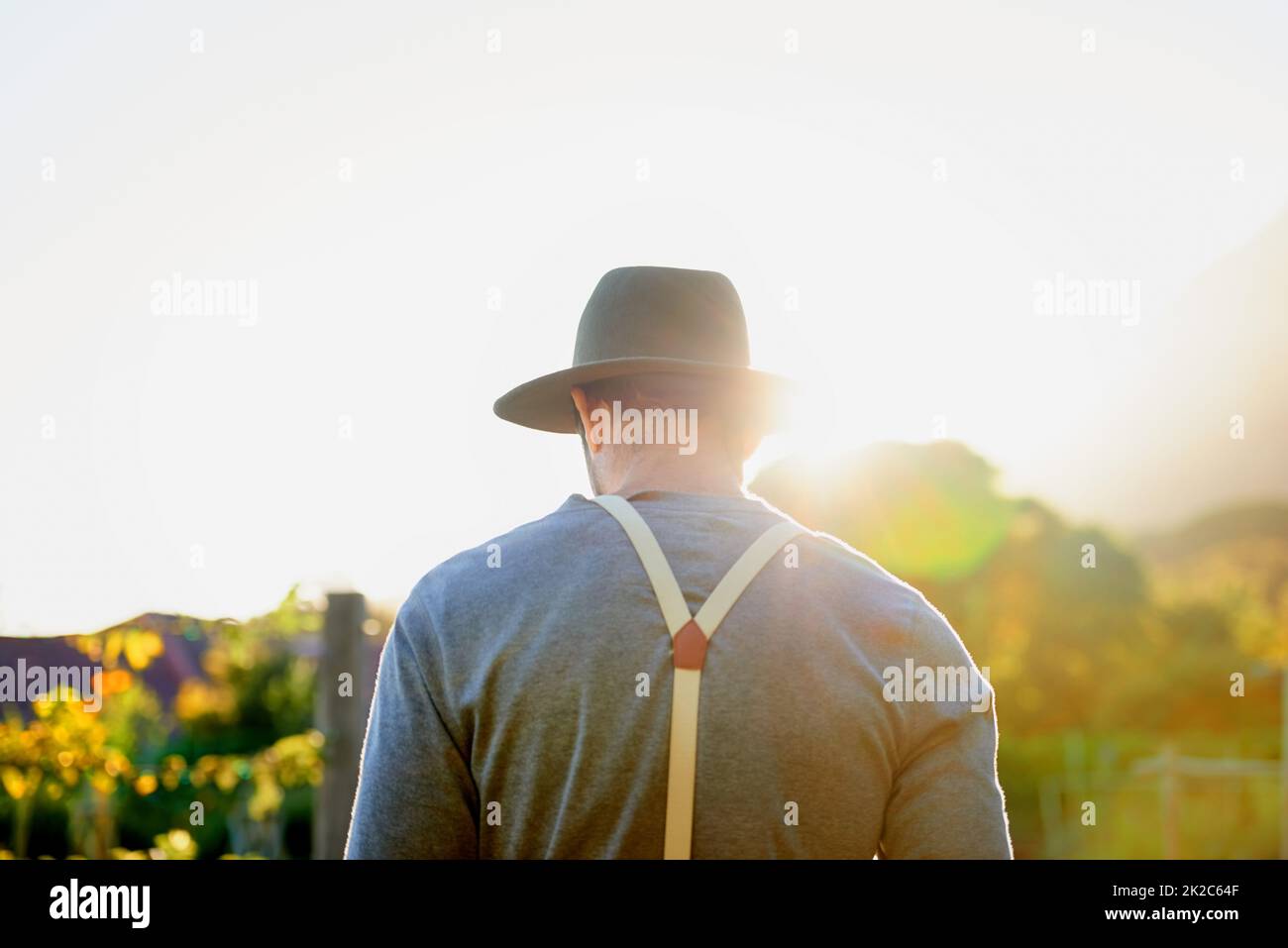 Into the garden he goes. Rearview shot of a man working on a farm. Stock Photo