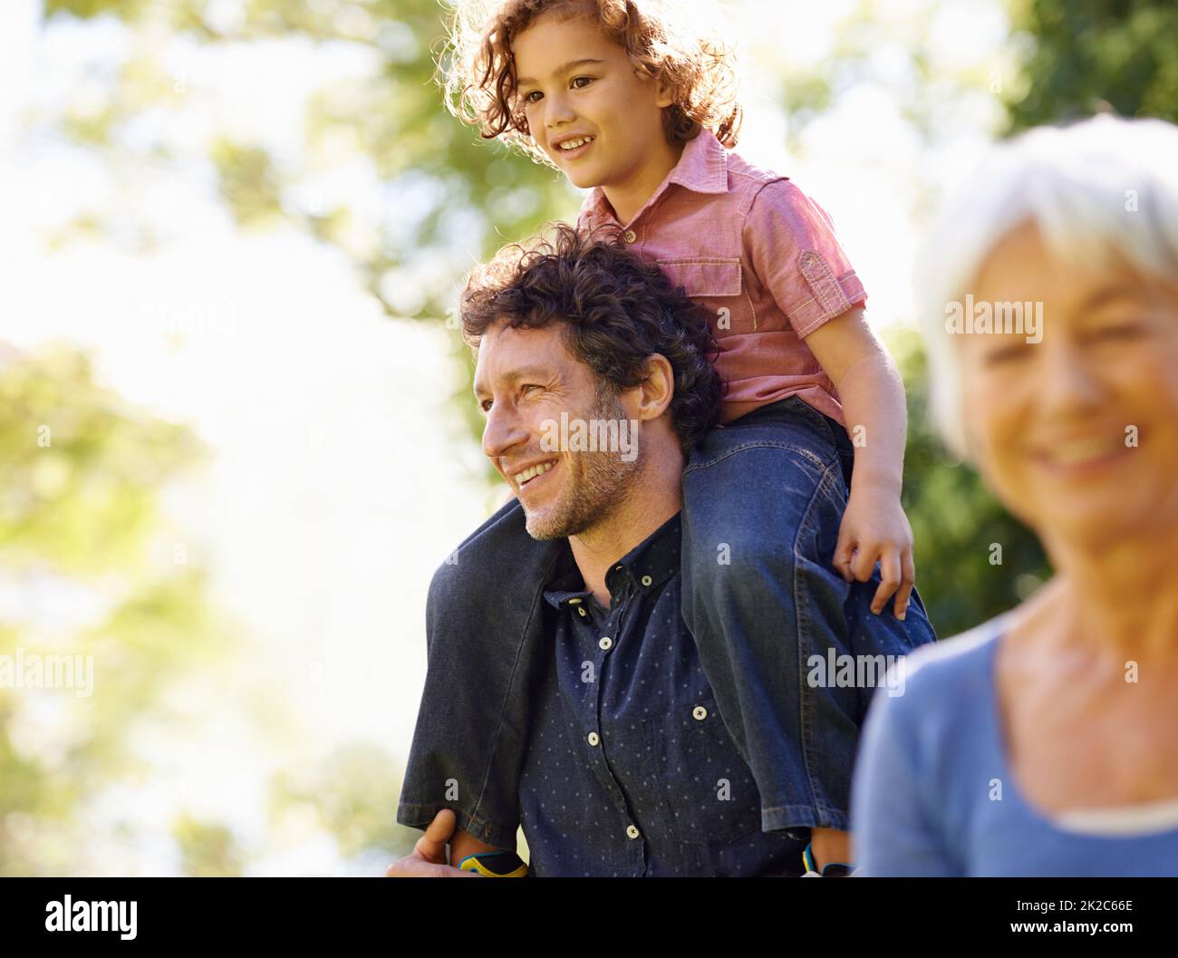 Spending the day with his little buddy. Shot of a young boy riding on his fathers shoulders. Stock Photo
