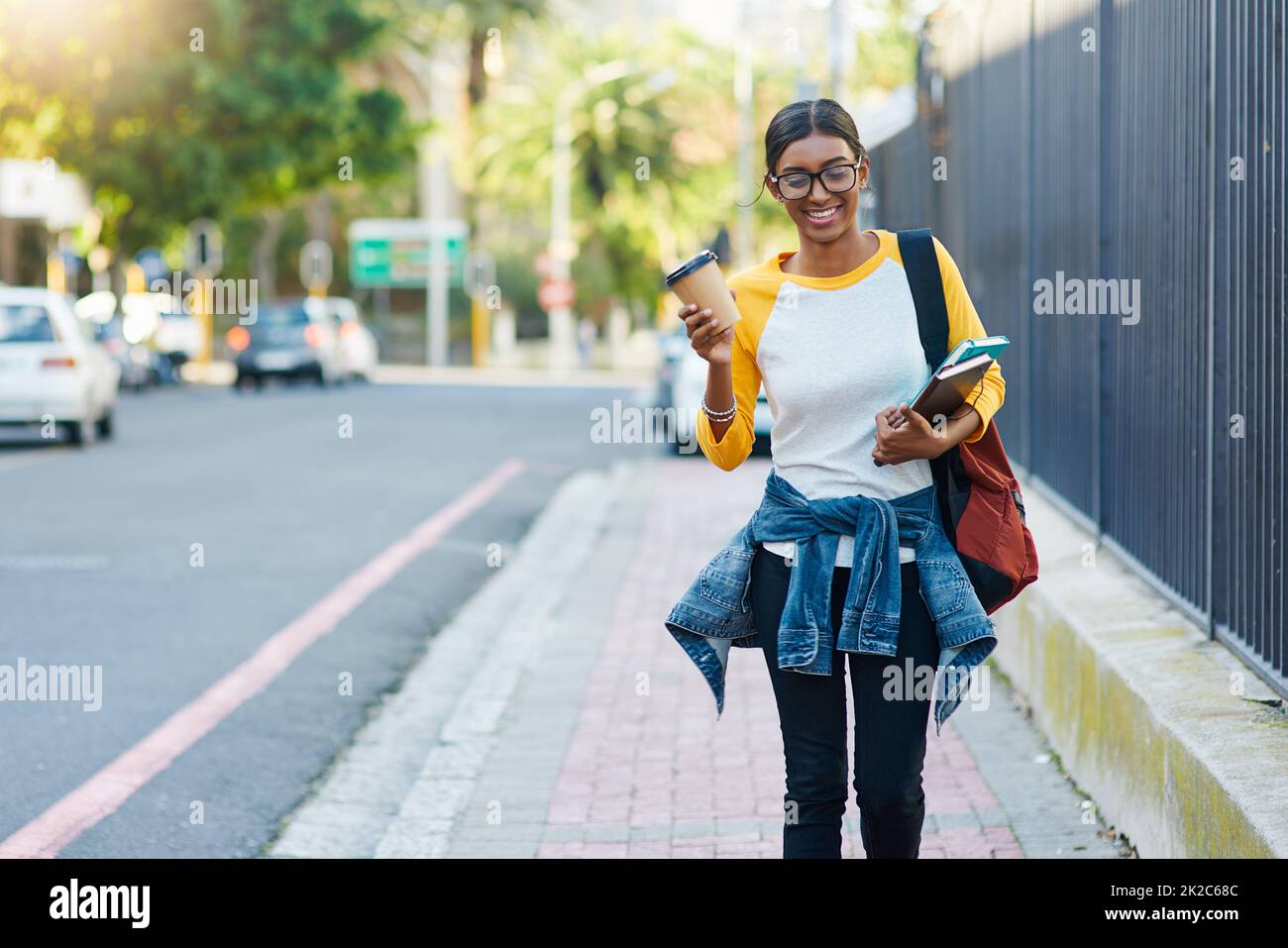 Got my coffee to commute to college. Cropped shot of a young female student commuting to college in the city. Stock Photo
