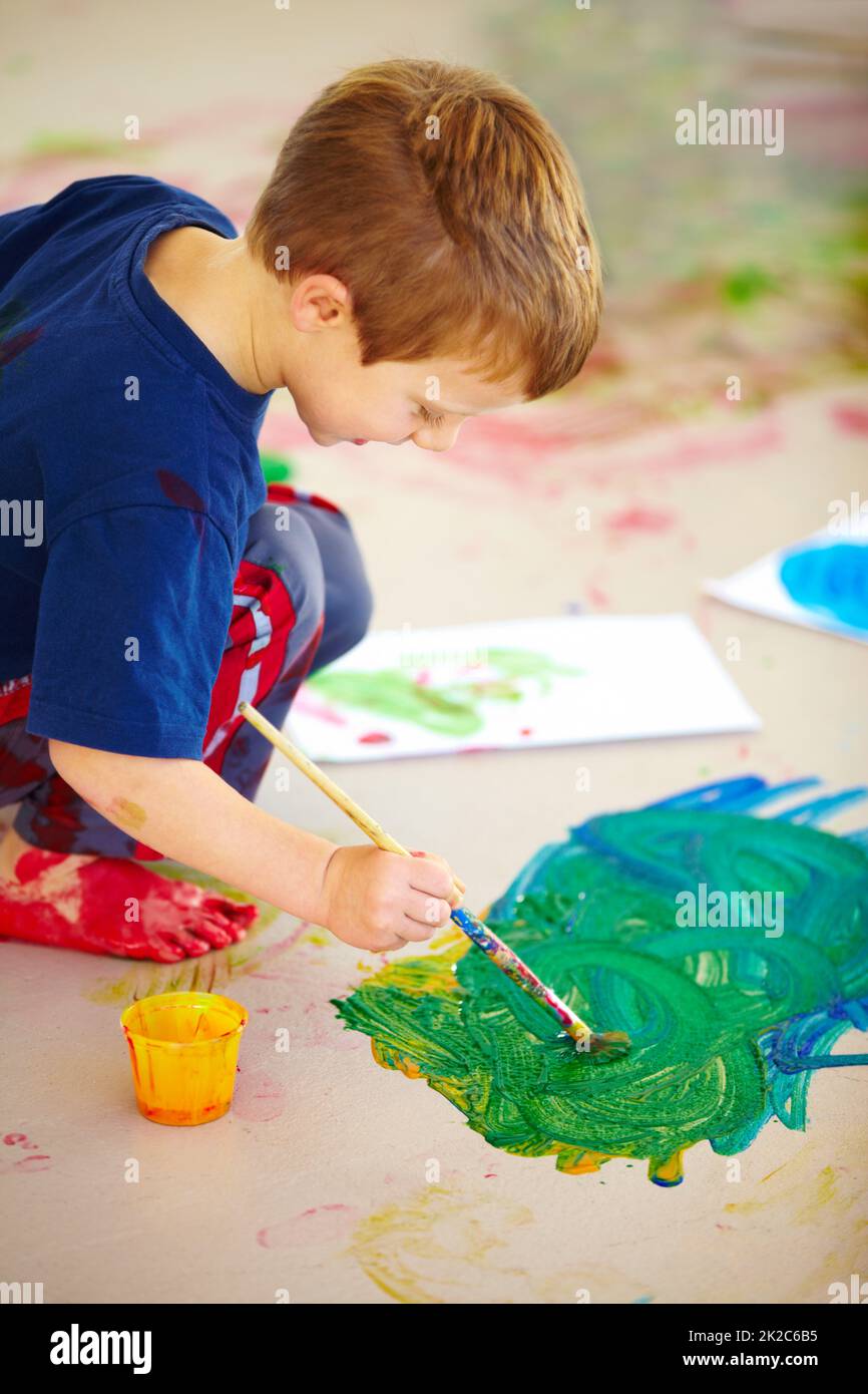 Feeling creative. Cute little boys using fingerpaint on the floor Stock
