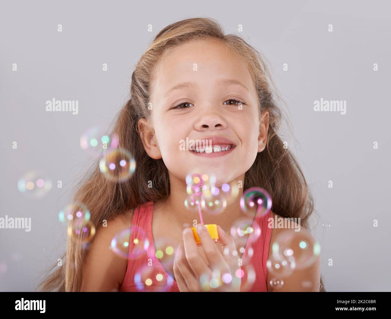 Fun with bubbles. An adorable little girl surrounded by bubbles Stock