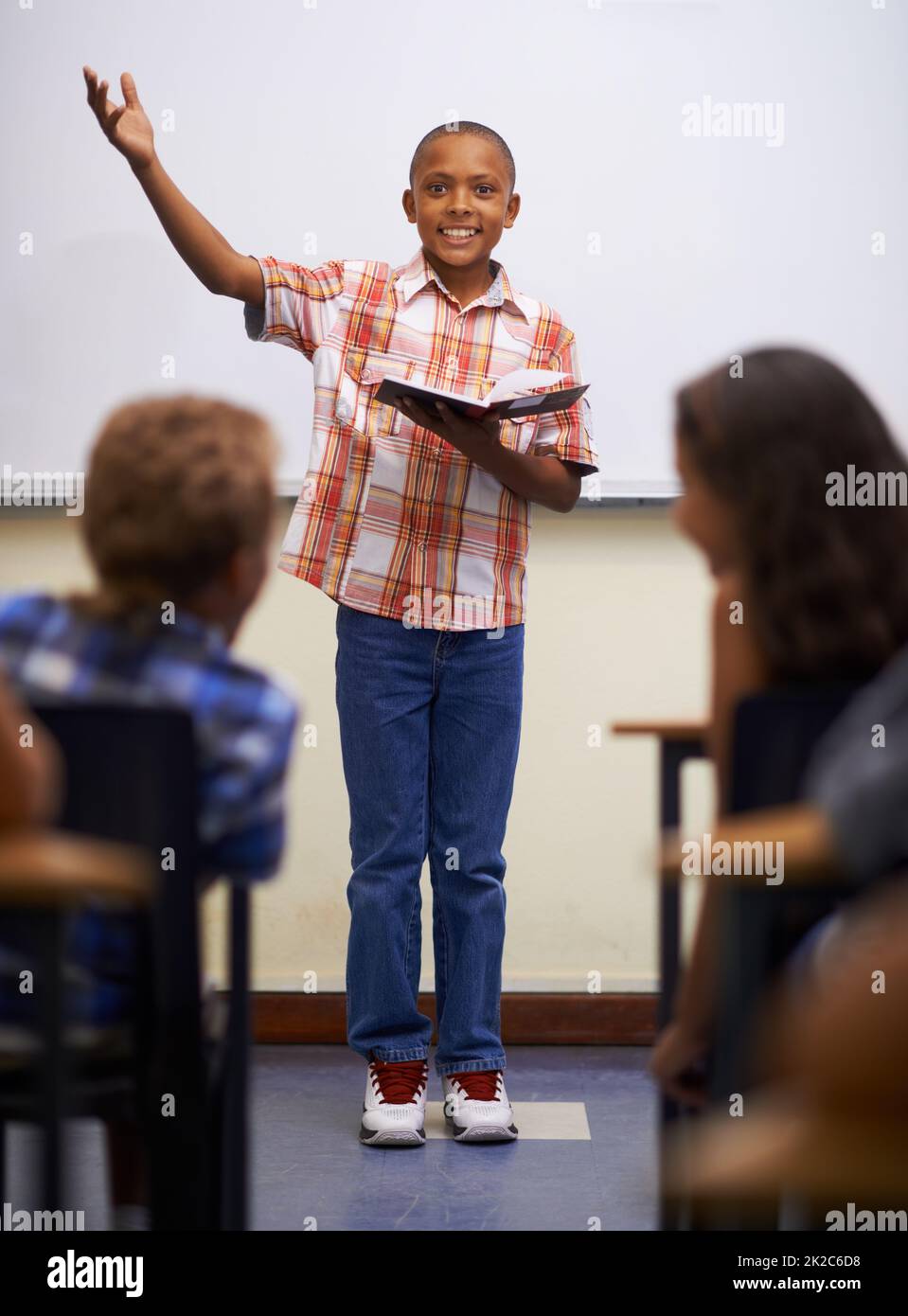 Doing his prepared reading. A young boy doing prepared reading at the front of the class. Stock Photo