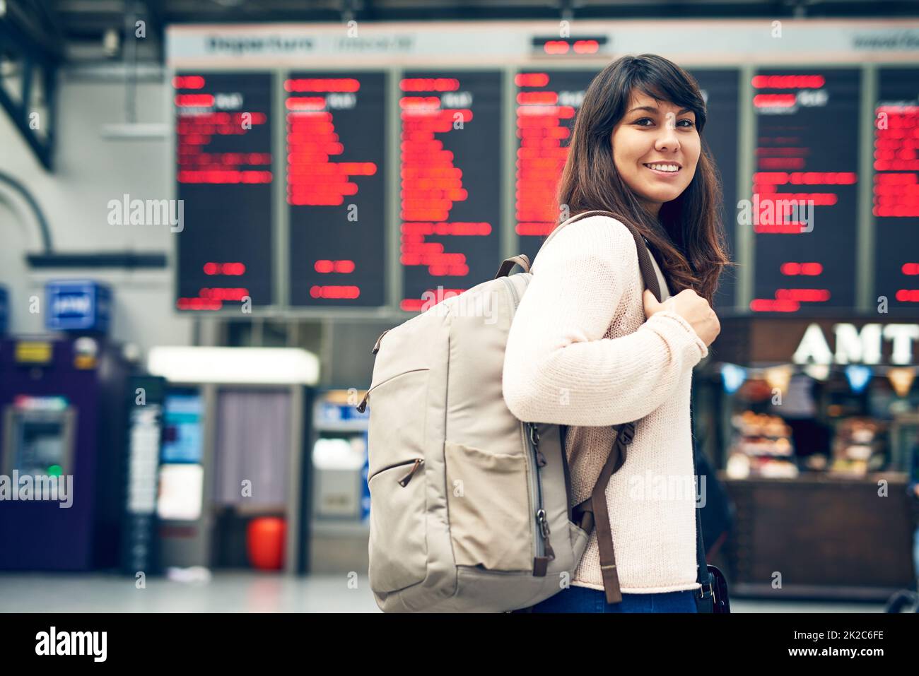 Im excited to travel. Cropped portrait of an attractive young woman standing at an arrivals and departures board in the airport. Stock Photo
