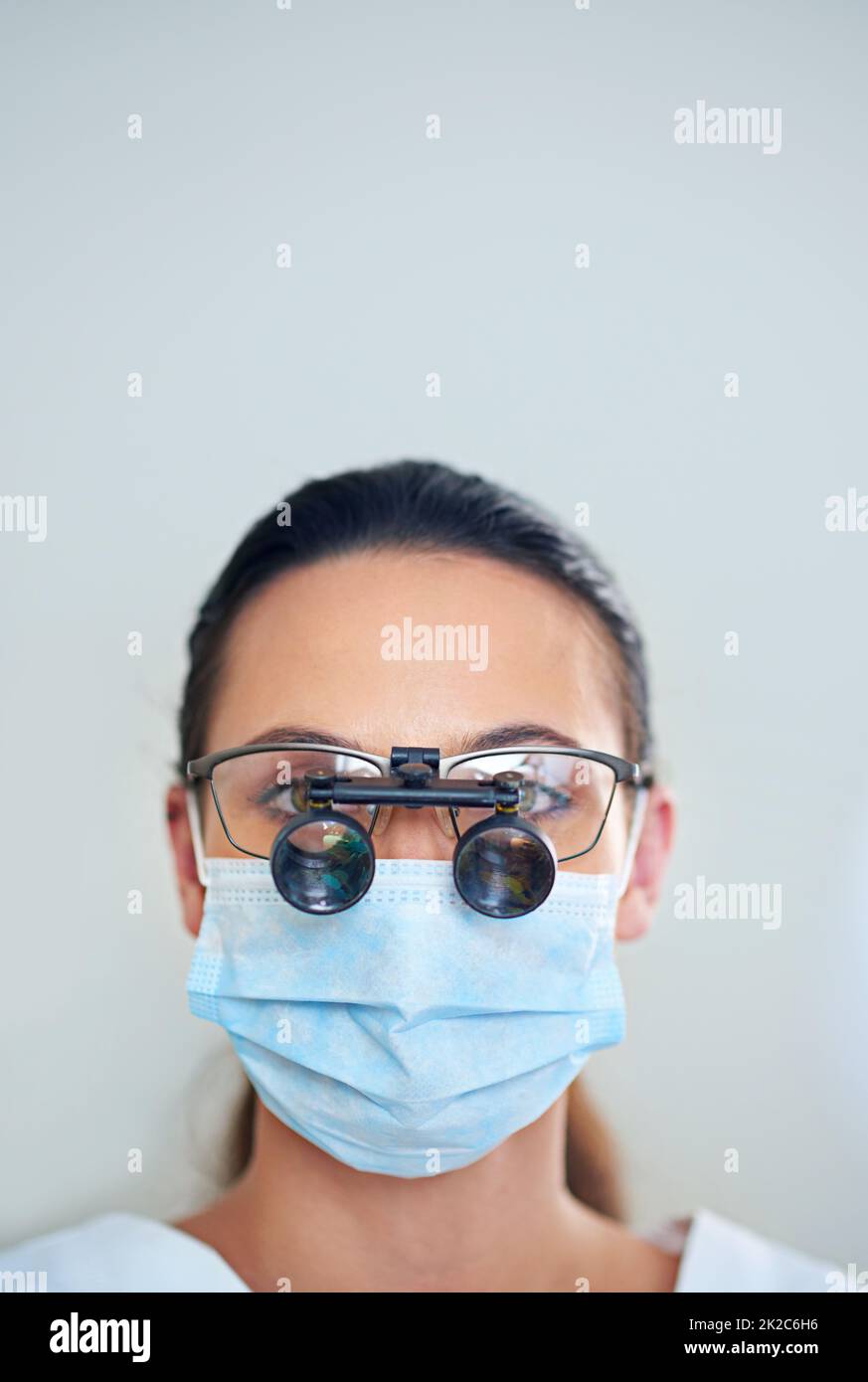 Lets take a closer look. Portrait of a young female dentist wearing magnifying glasses. Stock Photo
