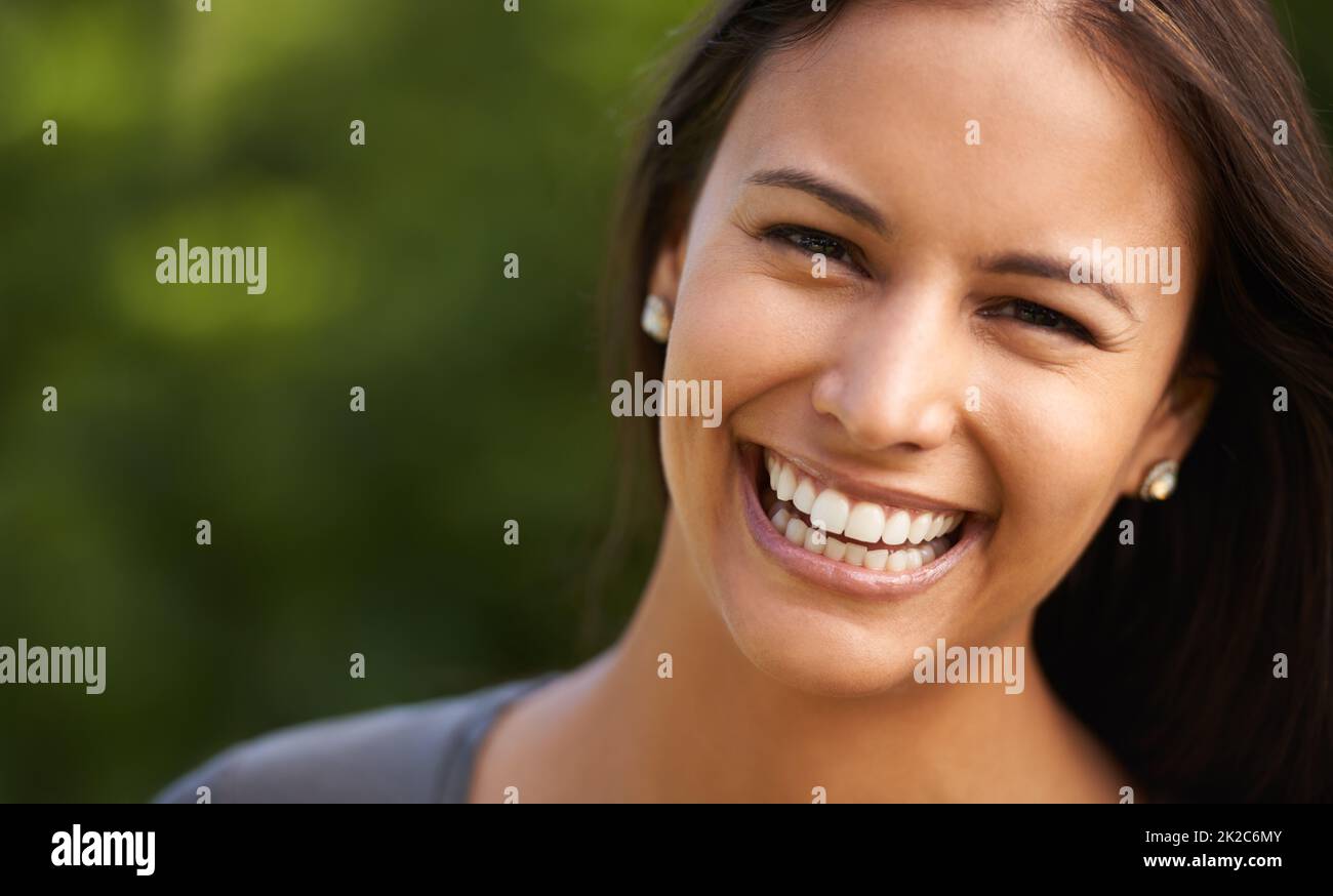 Ultimate joy. A beautiful young woman smiling outdoors. Stock Photo