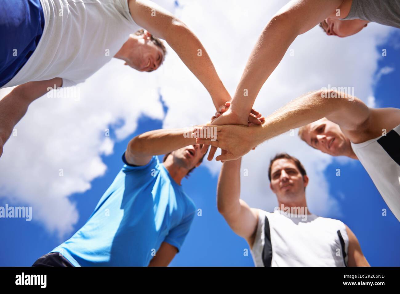 Lets do this team shot of a group of young sportsmen piling their