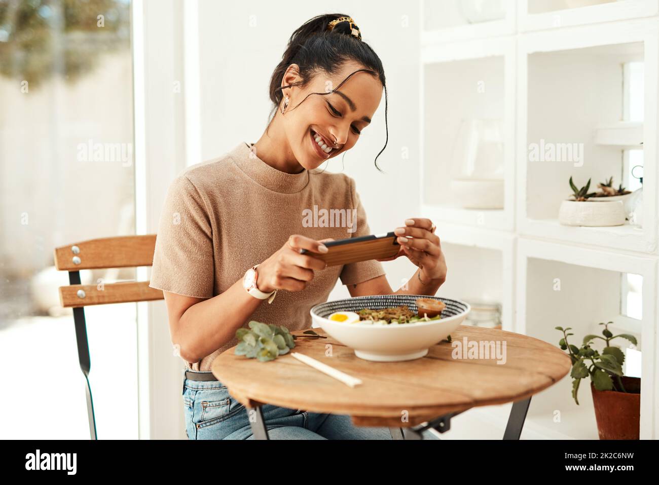 This looks so delicious. Cropped shot of an attractive young businesswoman using her cellphone to take pictures of her lunch for her blog. Stock Photo
