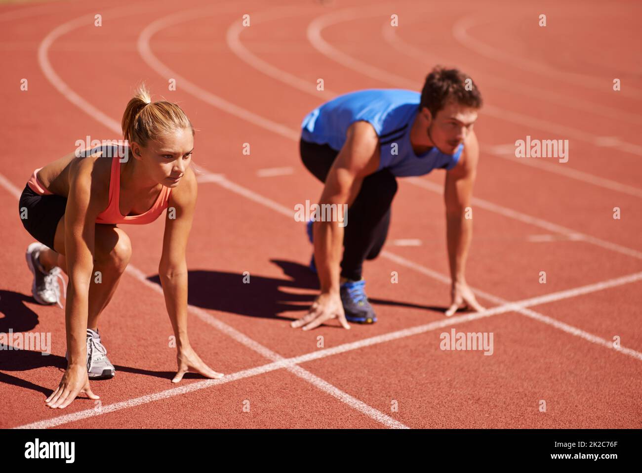 Ill take you on. Shot of two young people getting ready to race on an athletics track. Stock Photo