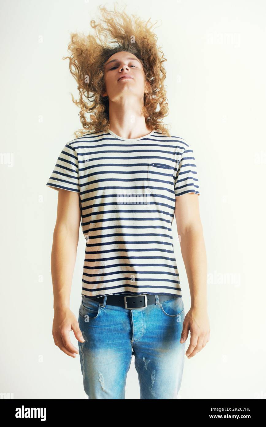 Shaking it all loose. Young man with curly long hair headbanging Stock