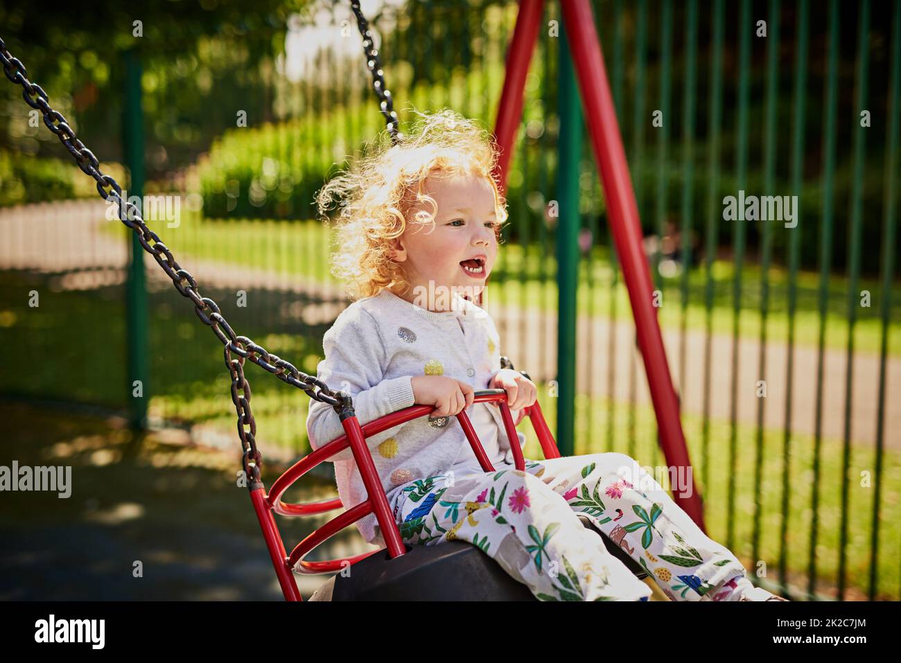 Swinging into a day of fun. Shot of an adorable little girl playing on the swing outdoors. Stock Photo