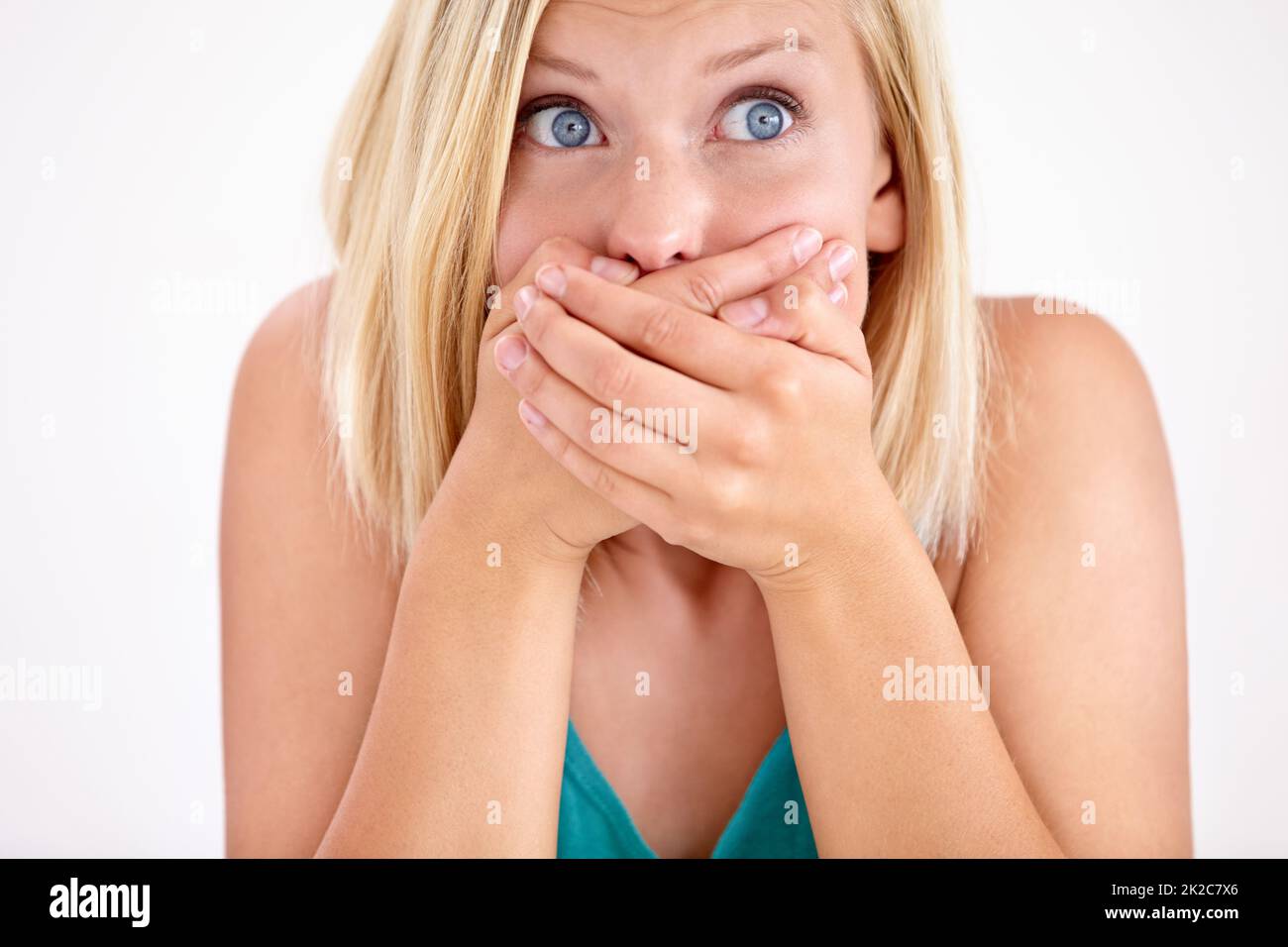 She cant believe it. A young woman holding her mouth in disbelief. Stock Photo
