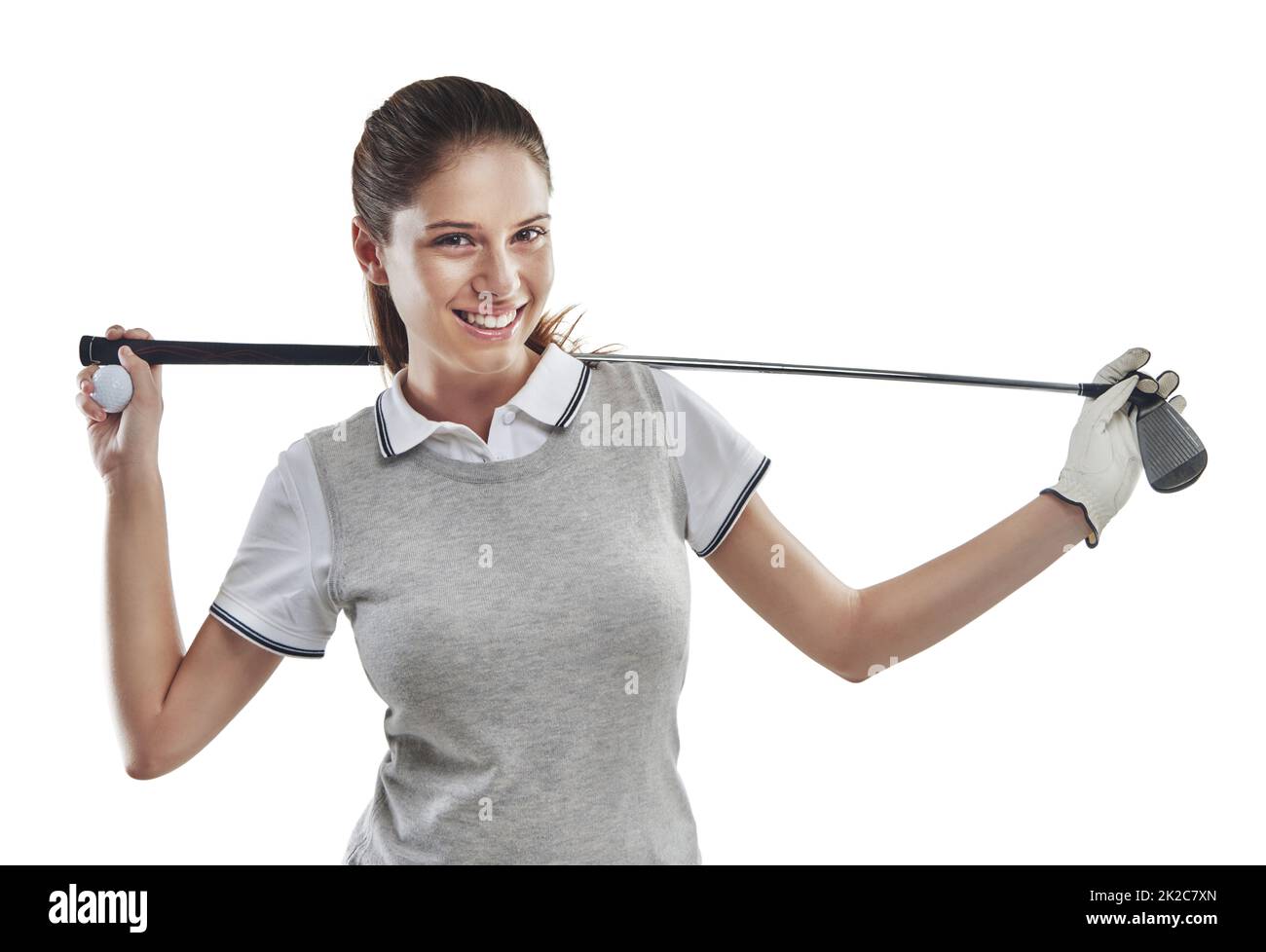 Golf gives good vibes. Studio shot of a young golfer holding a golf club behind her back isolated on white. Stock Photo