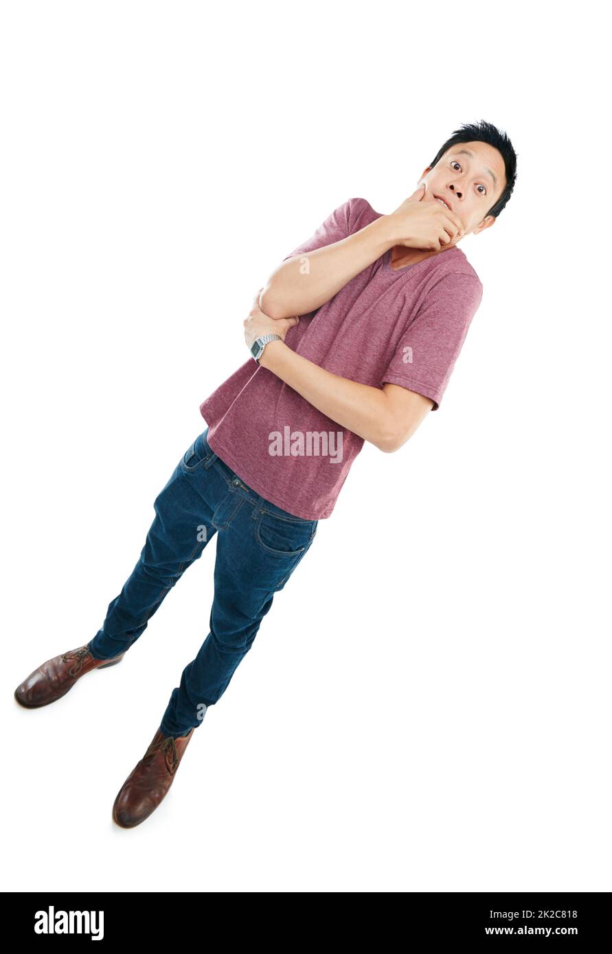 Is the world tilting, or is it just me. Tilted studio portrait of a young man looking tense against a white background. Stock Photo