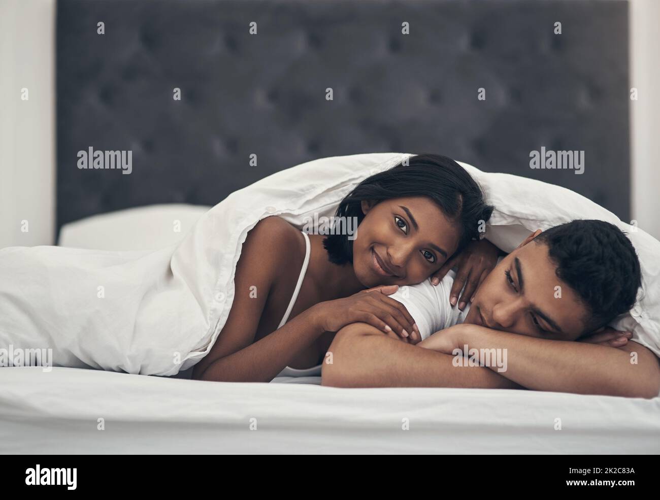 He always falls asleep before me. Shot of a young couple laying in bed at home. Stock Photo